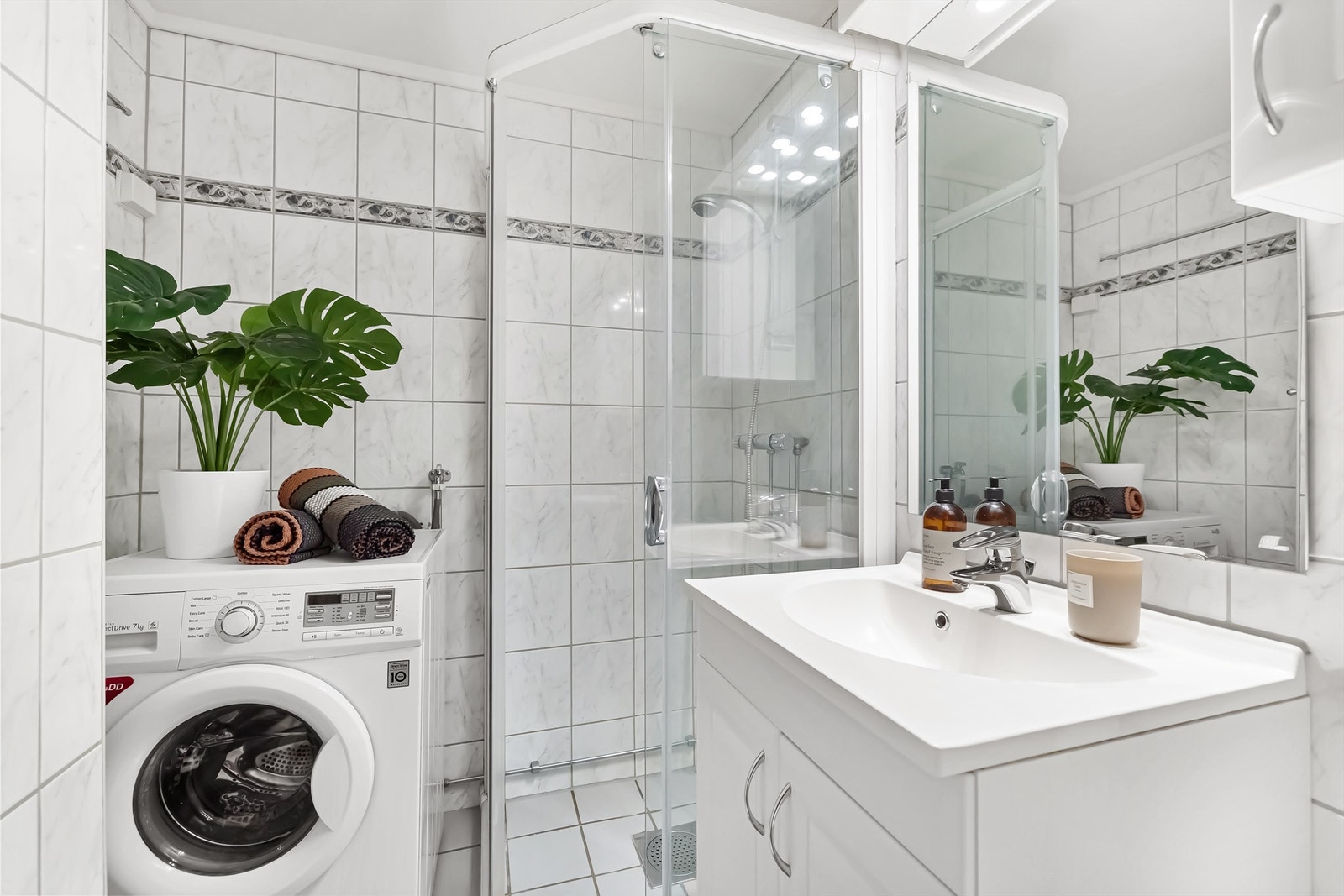 Baderomsinnredning med både vegghengt skap og servantskap, servant med ett-greps armatur, frittstående toalett og dusjhjørne Galleribilde