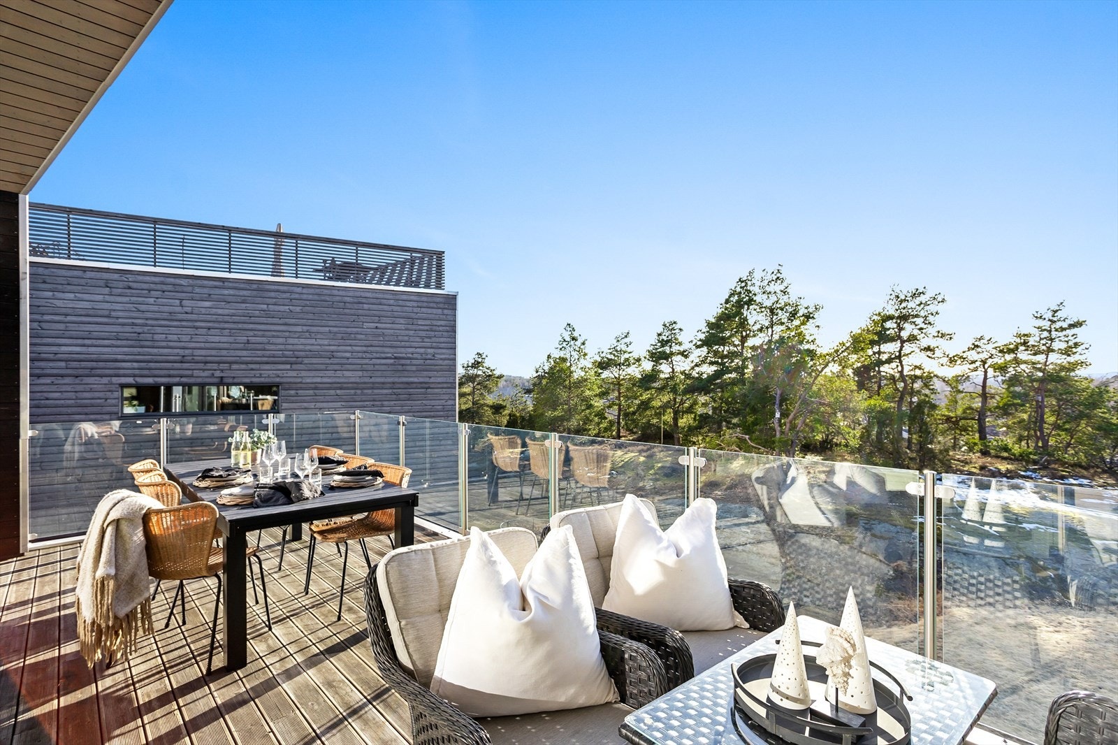 Balkongen er opparbeidet på dekke av tre og pent innrammet med rekkverk i glass. Galleribilde