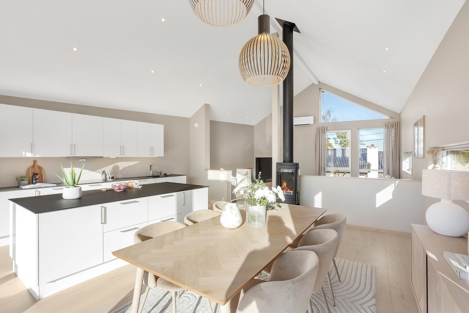 Kjøkkeninnredningen er moderne og delikat med slette fronter i lys utførelse og matchende, mørk benkeplate. Galleribilde