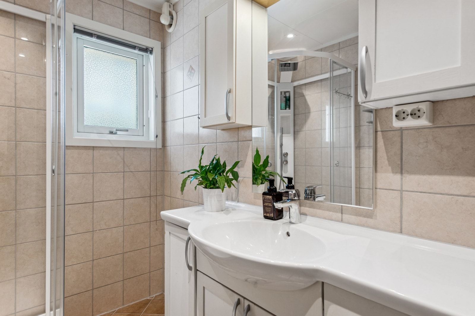 Videre er badet utstyrt med dusjkabinett med integrert dusjbatteri og vegghengt toalett. Galleribilde