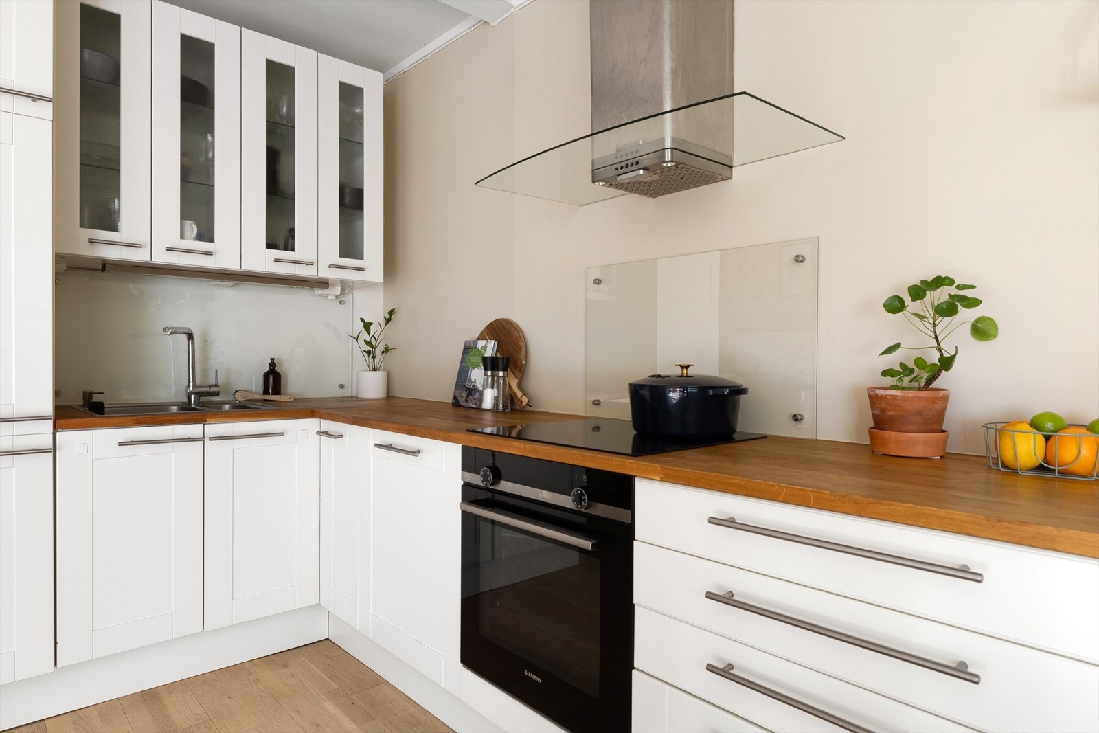 Integrerte hvitevarer på kjøkkenet som kjøl/frys, oppvaskmaskin, stekeovn og platetopp. Galleribilde