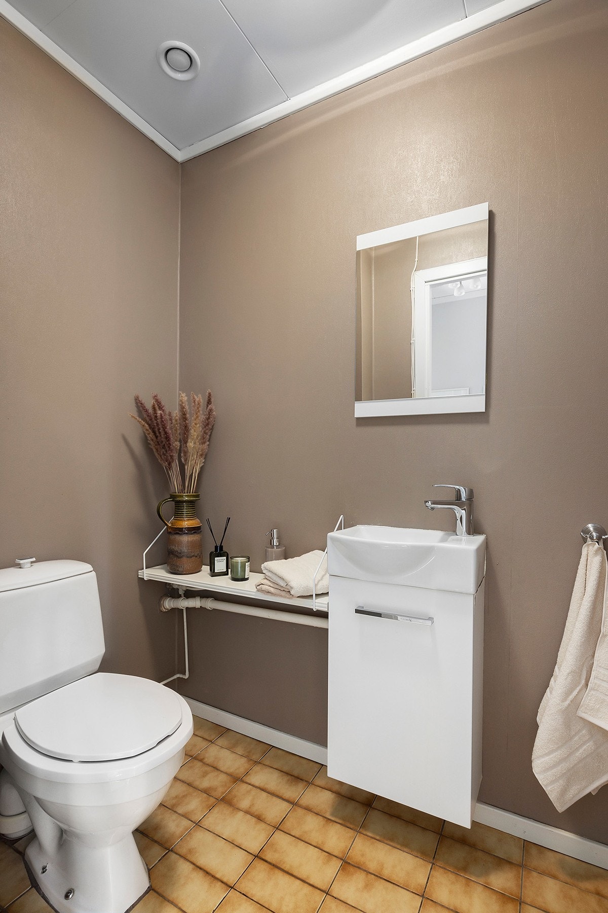 Toalettrom med flislagt gulv med varme og malte veggoverflater. Galleribilde