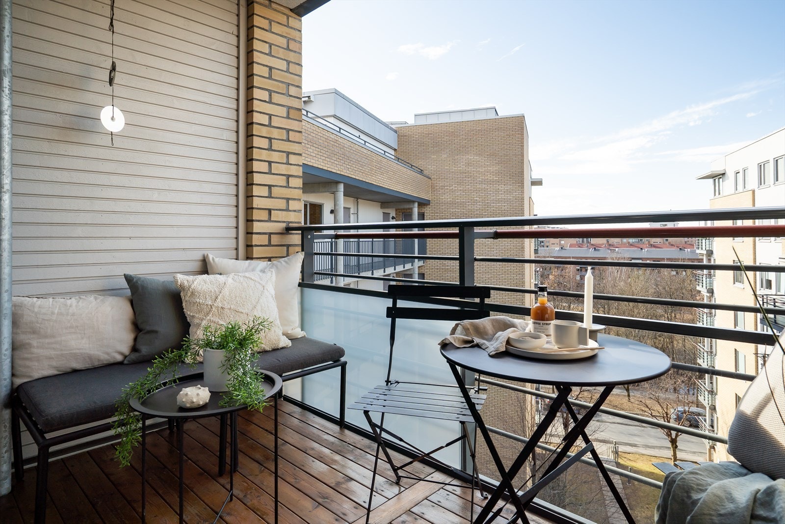 Balkongen ligger skjermet til, med utsyn ut over fellesarealer. Galleribilde