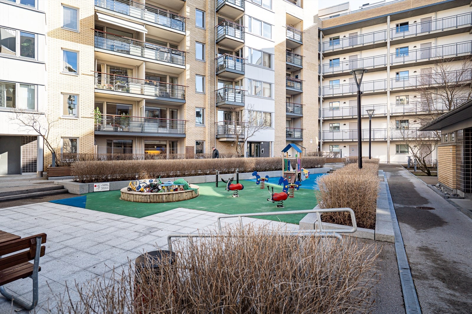 Pent opparbeidede fellesarealer med sitteplasser og lekeareal. Galleribilde