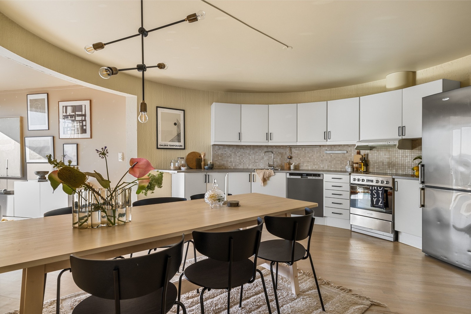 Kjøkkenet har en tidløs innredning med lyse, slette fronter, laminat benkeplate og flislagt backsplash. Galleribilde