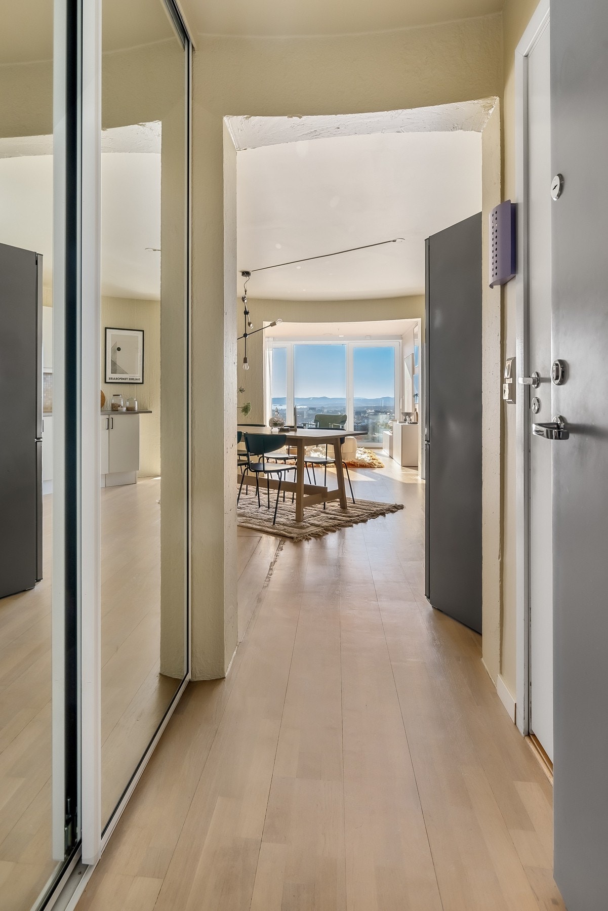 Lys og innbydende entré med god plass til oppbevaring av yttertøy og sko i skyvedørsgarderobe med speilfronter. Galleribilde