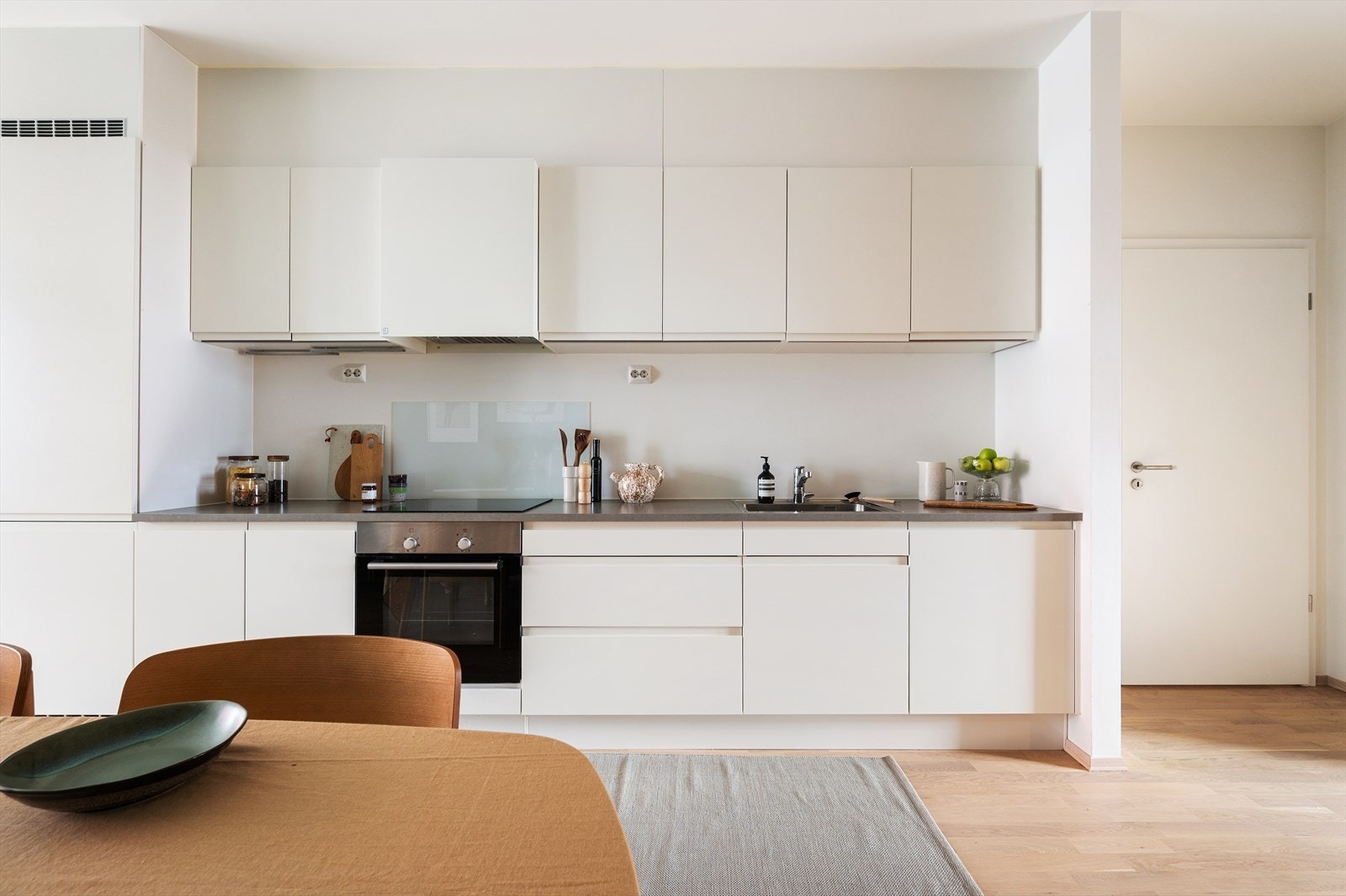 Laminat benkeplate står i fin kontrast til de hvite frontene og gir en praktisk arbeidsflate som er enkel å vedlikeholde. Galleribilde