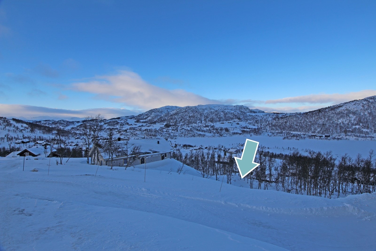 Tomten ligger i skrånende terreng, og strekker seg opp til hytteveien. Galleribilde