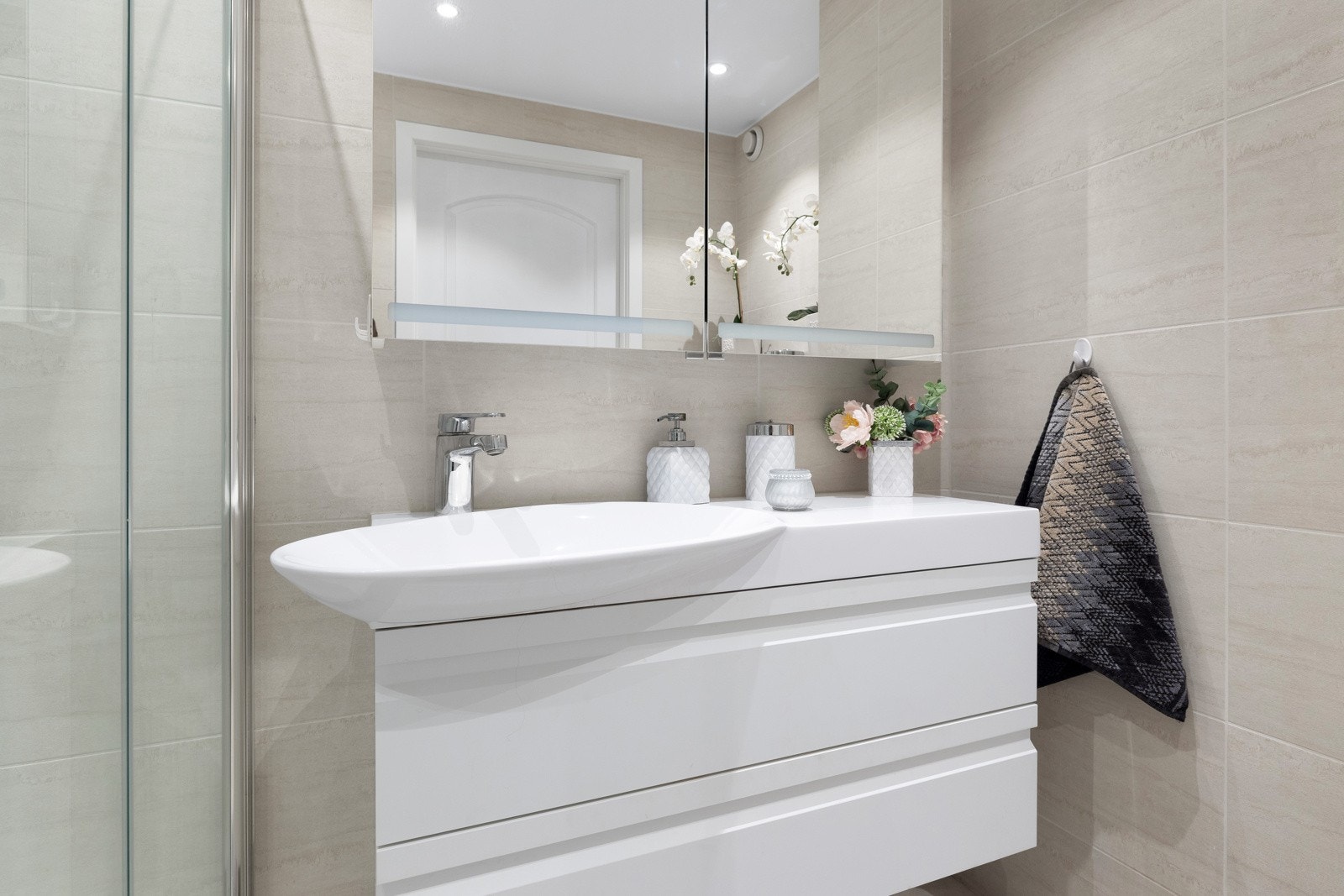 Den stilrene baderomsinnredningen byr på rikelig med oppbevaringsplass. Galleribilde