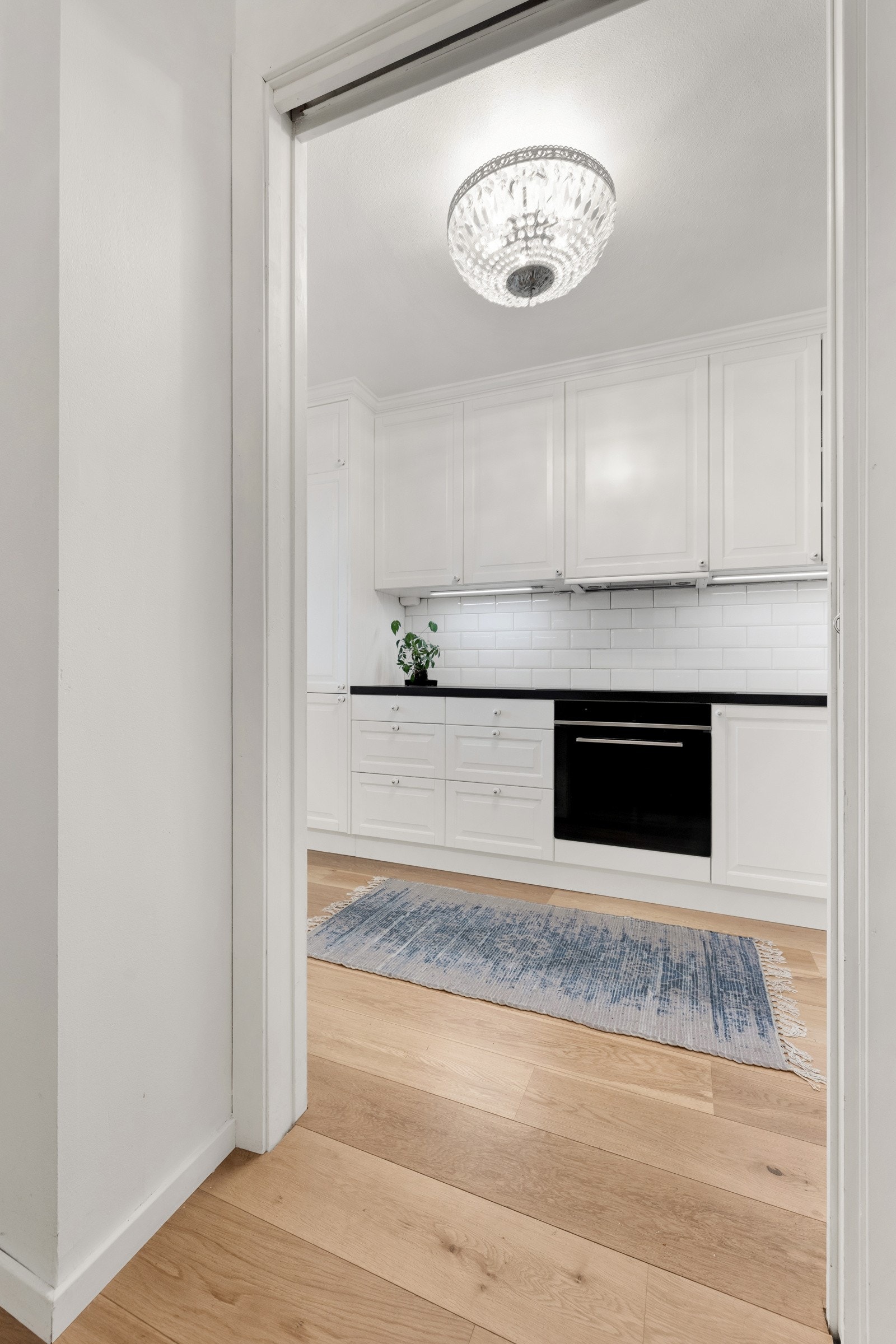 Mellom entreen og kjøkkenet er det en praktisk, plassbesparende skyvedør. Galleribilde