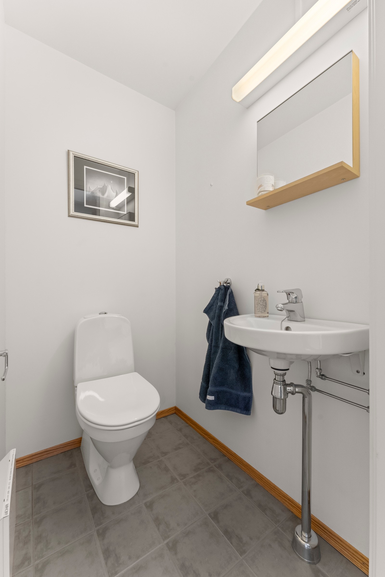 Et ekstra gjestetoalett er praktisk. Her er det fliser på gulvet, servant, speil og toalett. Galleribilde