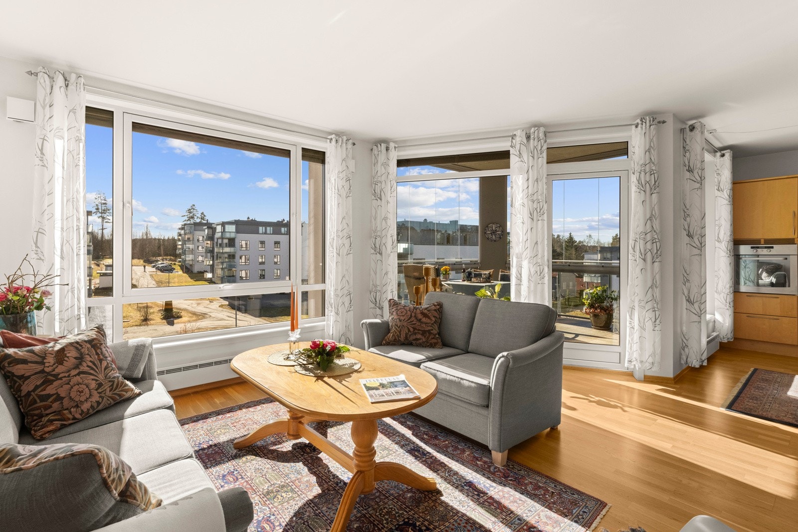 Stuen bades i dagslys fra store vindusflater og ligger i en sosial, åpen løsning med kjøkkenet. Galleribilde