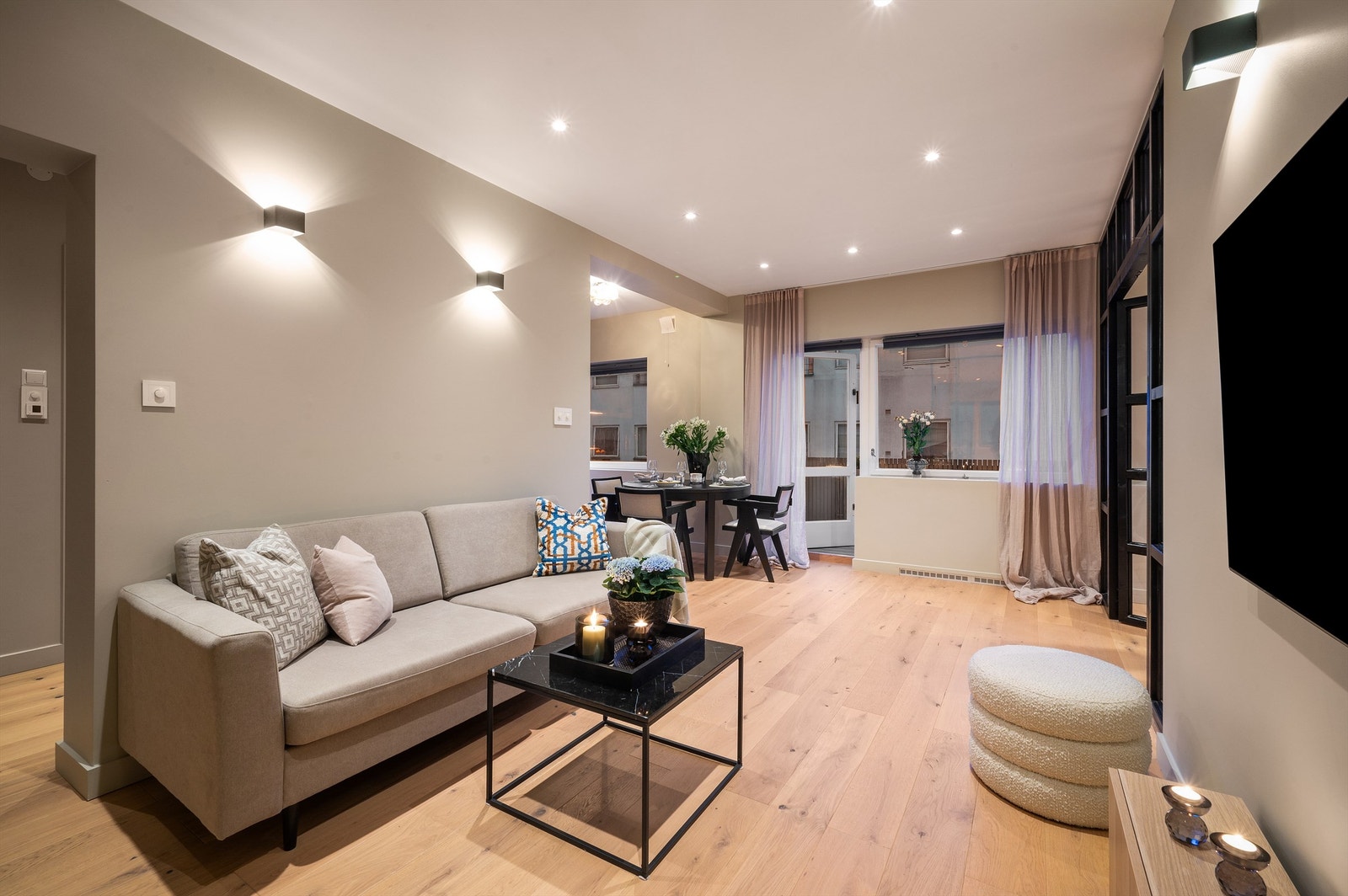 Gulvet er lagt med en lekker en-stavs parkett som harmonerer fint med de gråmalte, slette veggene og listfrie overganger til hvit himling med downlights. Galleribilde