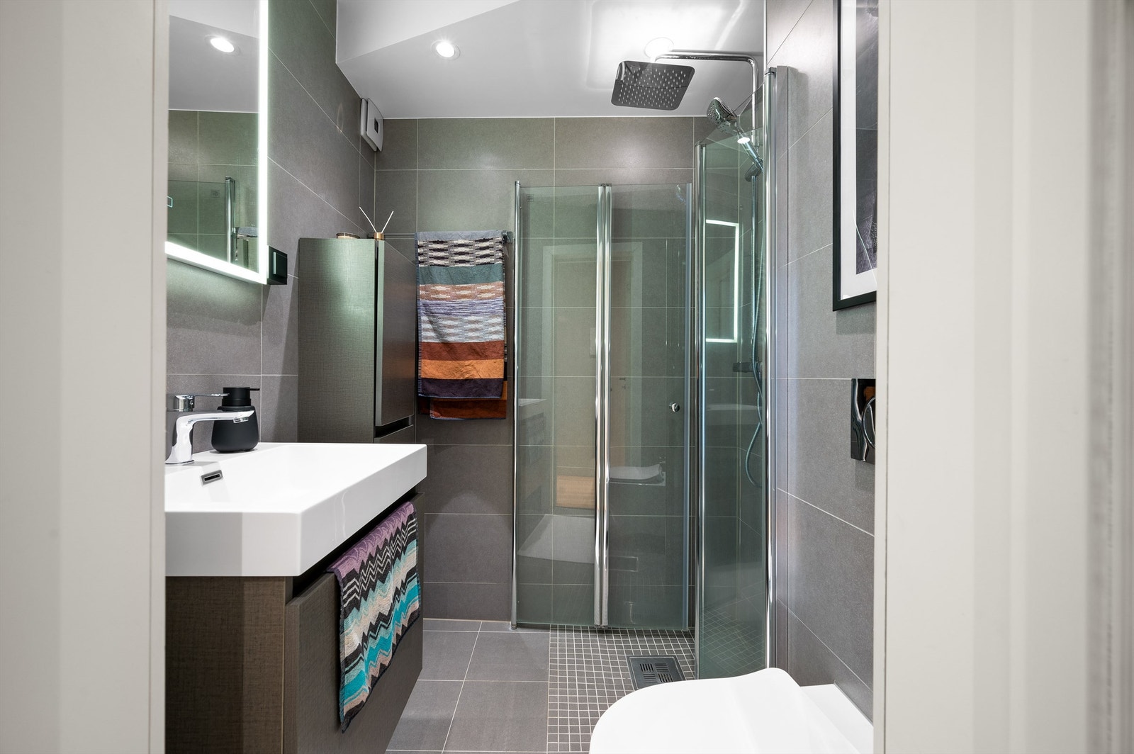 Delikat flislagt baderom fra 2018 som innbyr til velvære med delikate farge- og materialvalg. Galleribilde