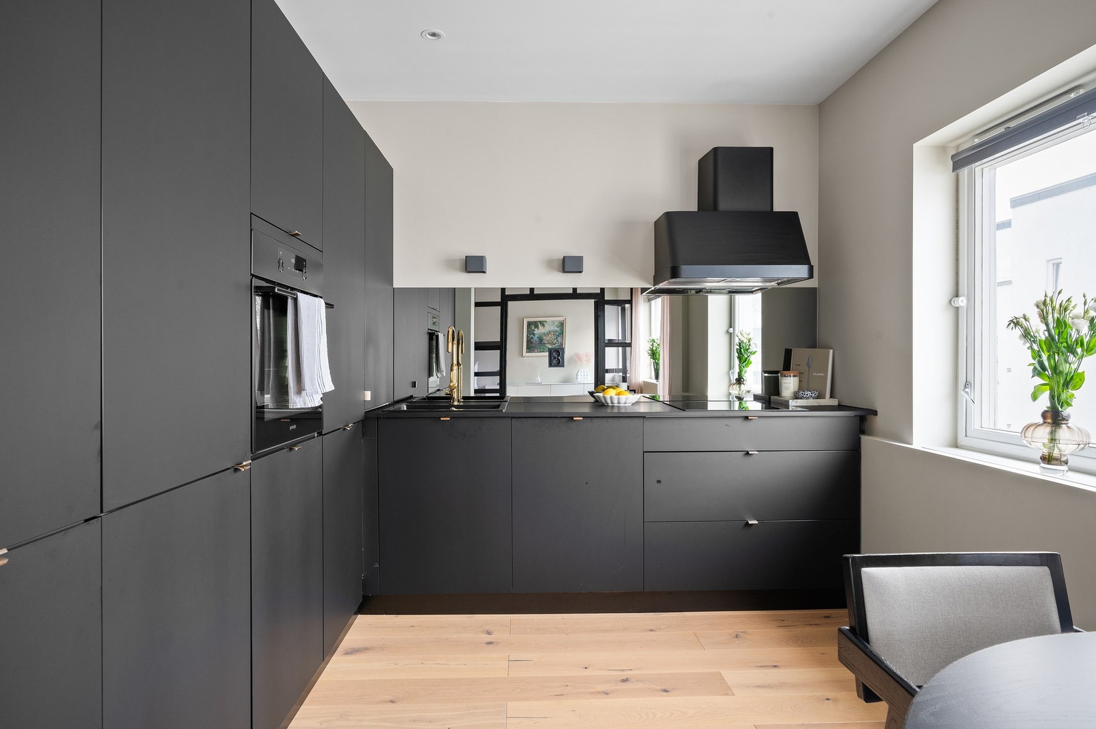 Delikat innredning fra Kvik med lekre detaljer som sorte, matte skapfronter, matchende laminat benkeplate med nedfelt kum i sort kompositt. Galleribilde