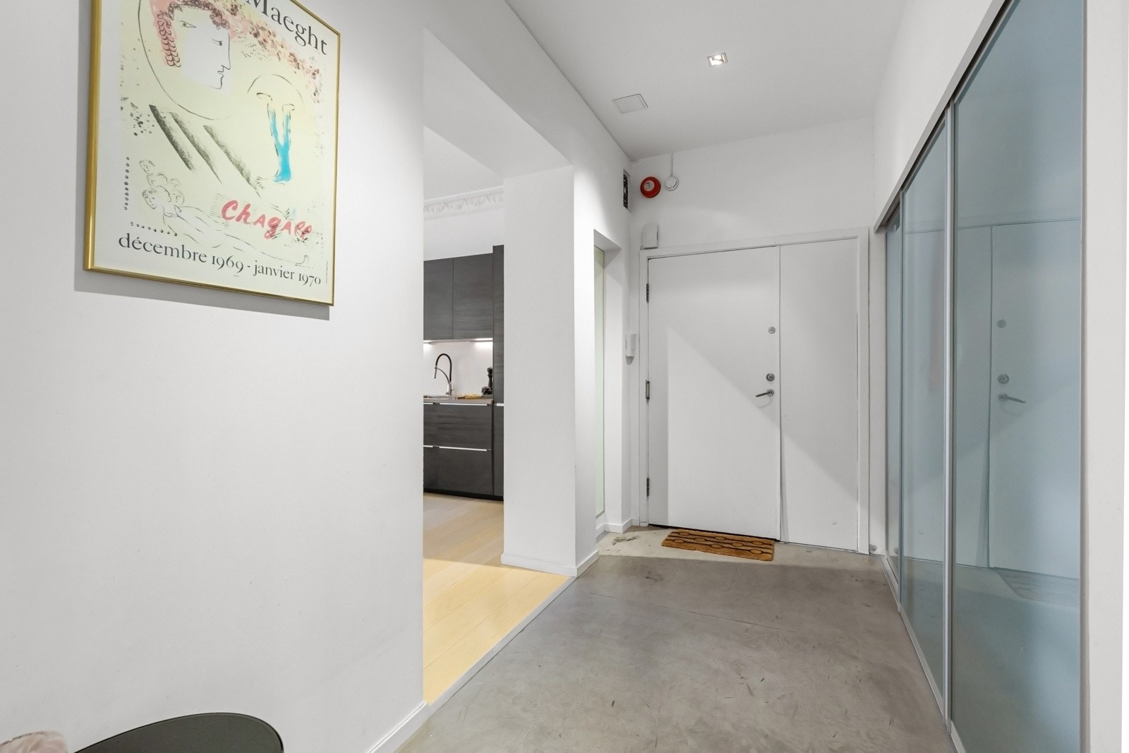 Stor entré med betonggulv og stor skyvedørsgarderobe Galleribilde