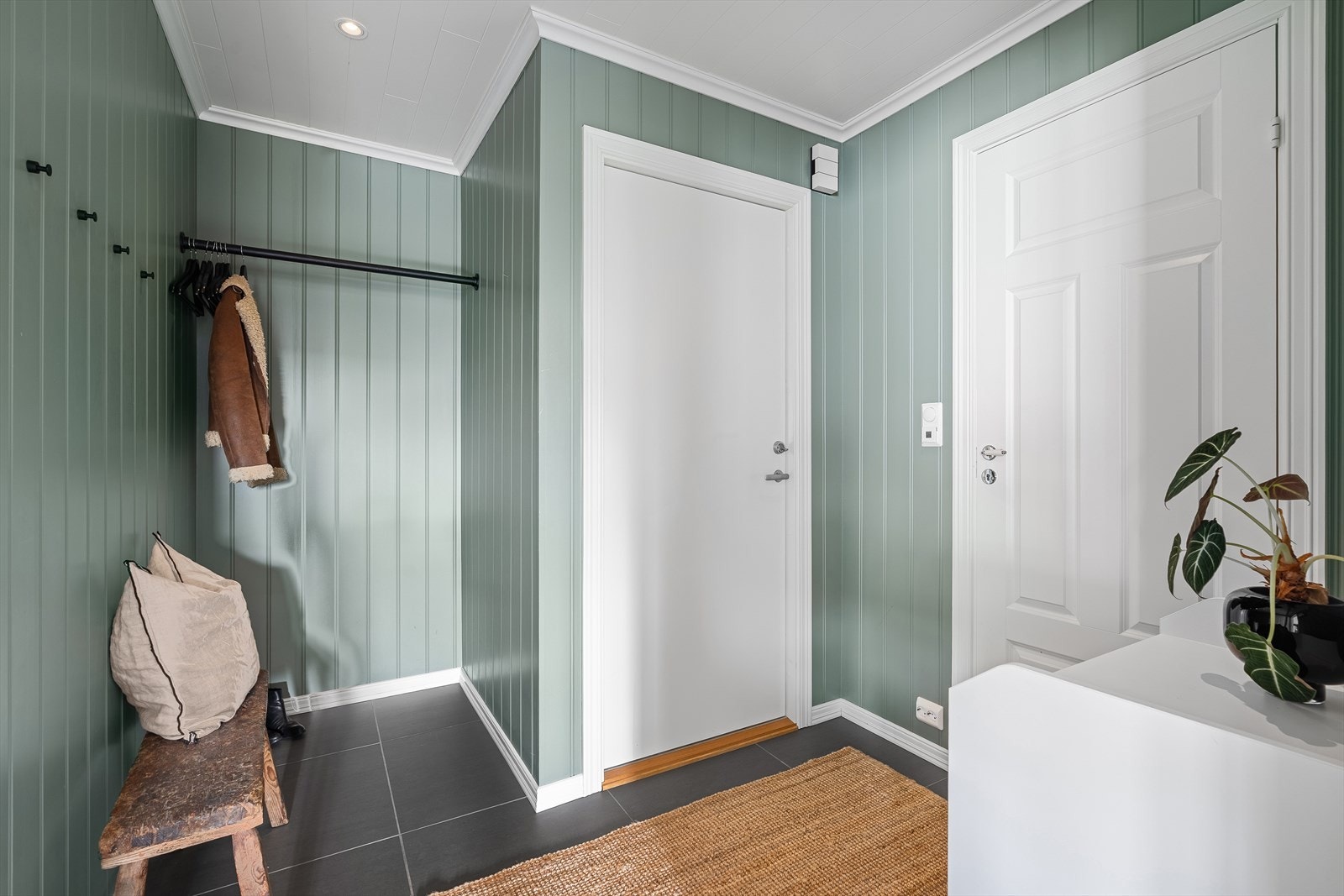 Velkommen inn! Leiligheten er svært innbydende og flott oppusset! I entreen er det lagt fliser på gulvet med varmekabler, malte panelvegger og downlights i himling. Galleribilde