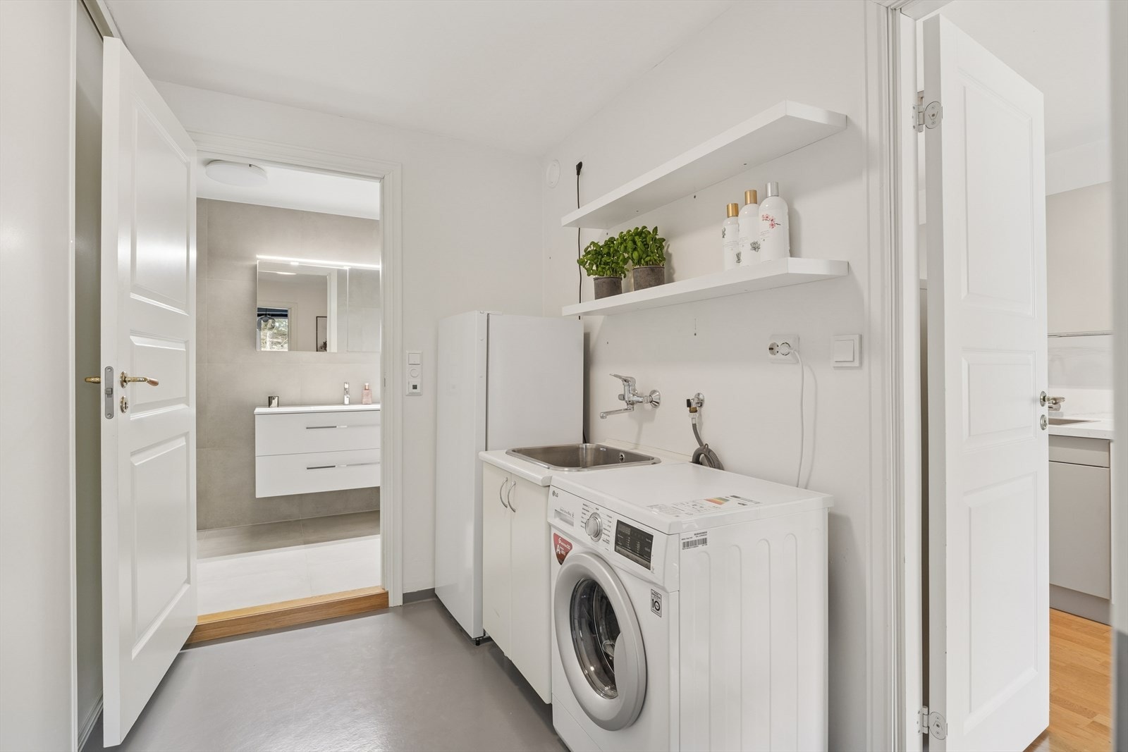 Eget vaskerom med praktisk skyvedørsgarderobe med tilgang til boligens andre bad Galleribilde