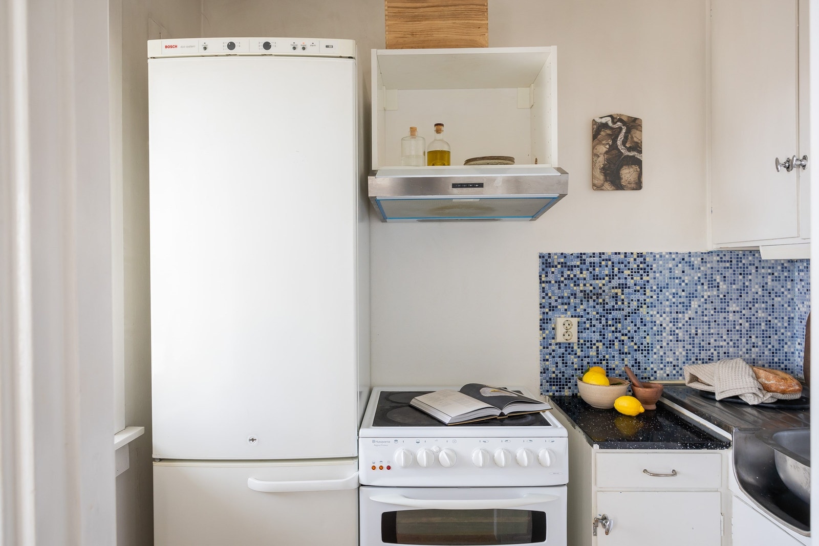 Mellom benkeplate og overskap er det flislagt med overbelysning og stikkontakter under overskapene. Galleribilde