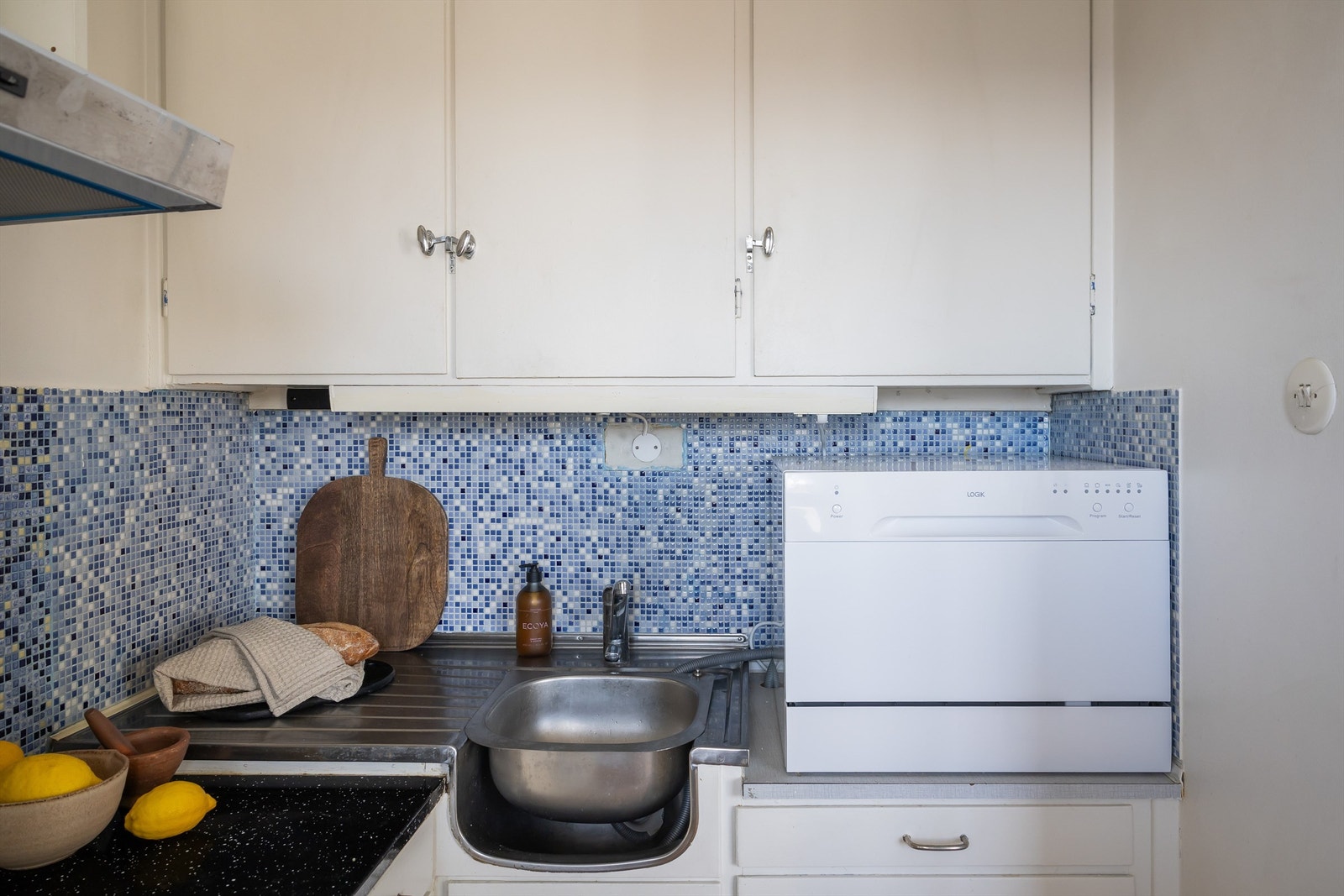 Det er rikelig med oppbevaringsplass i både skuffer og høye skap. Kjøkkeninnredningen er av glatte fronter og benkeplate i laminat med ovenpåliggende oppvaskkum. Galleribilde