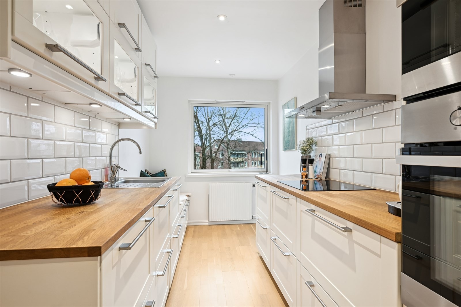 Kjøkkenet er praktisk innredet med skap- og benkeplass på begge sider. Galleribilde