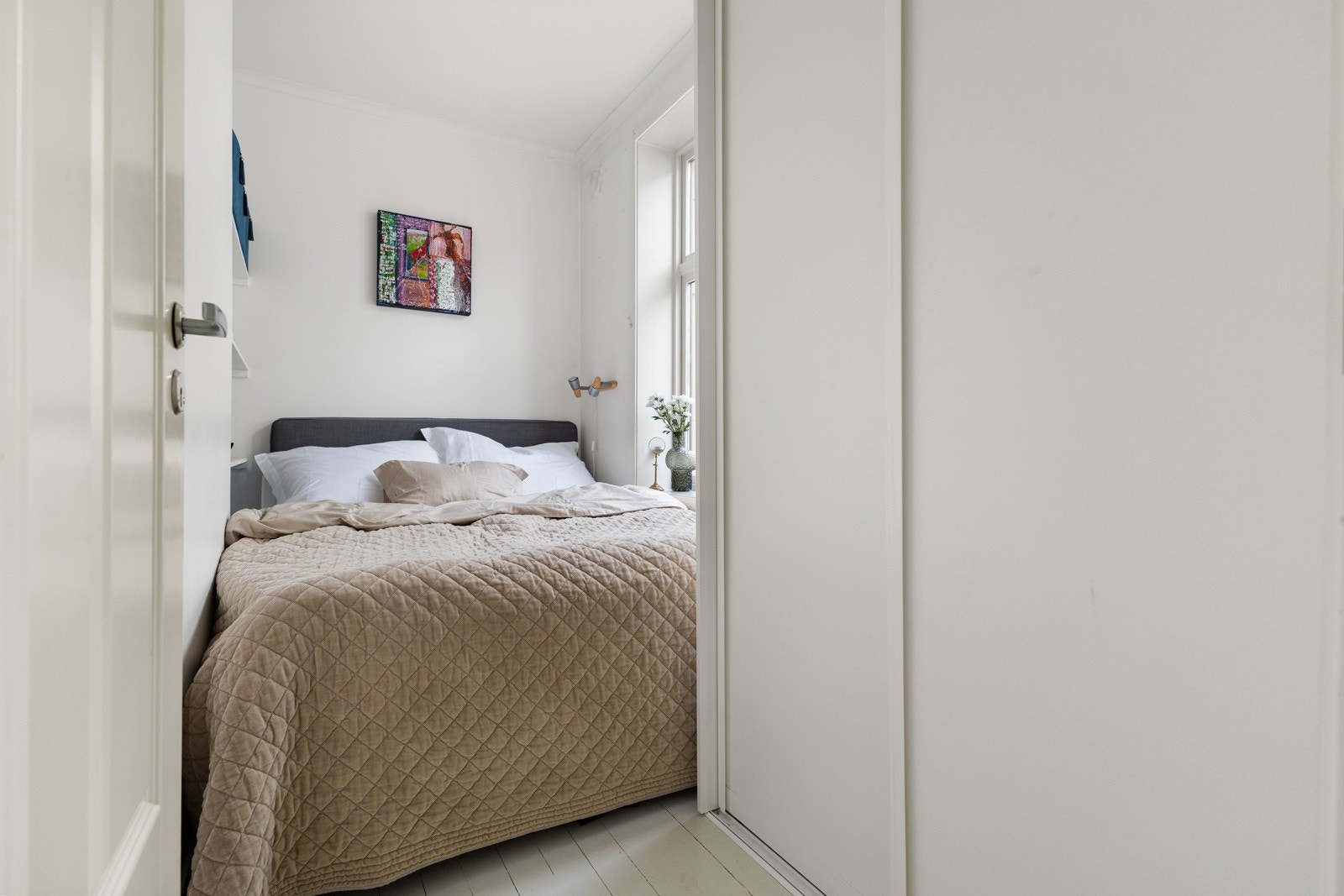 Lyst soverom med plass til dobbeltseng. Rommet har en praktisk skyvedørsgarderobe for god klesoppbevaring. Galleribilde