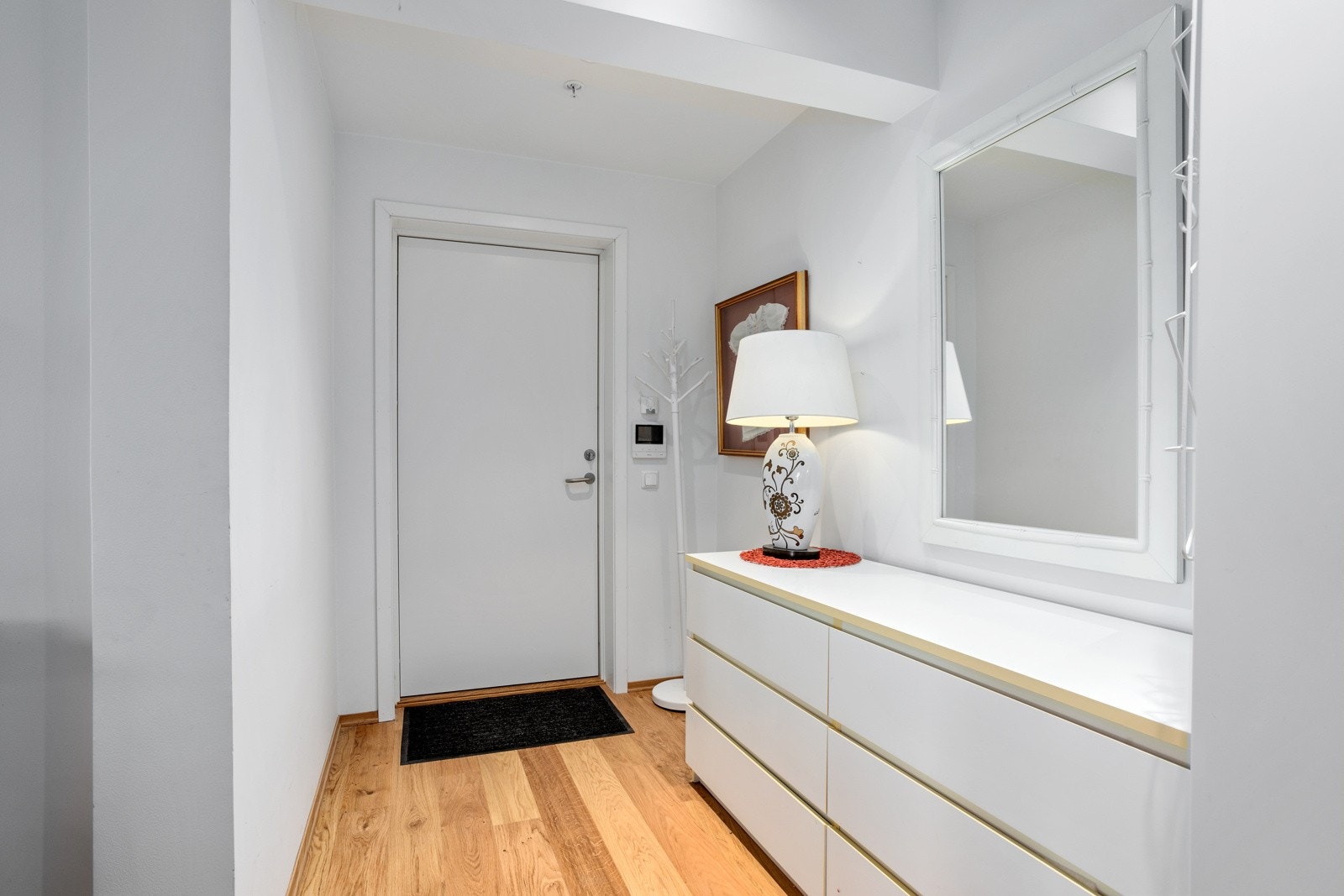 Lys og innbydende entré med god plass til kommode og garderobeløsning. Det er montert dørcalling med video i entréen Galleribilde