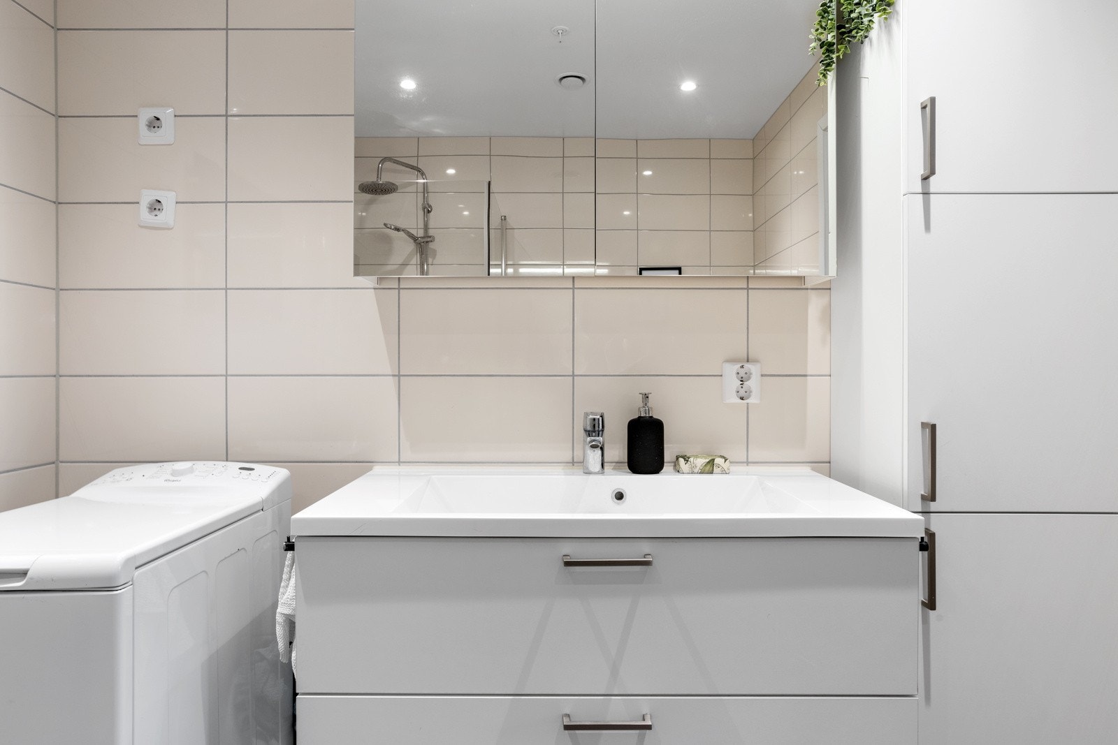 Vegghengt servantinnredning med skuffer, og ovenpåliggende servant. Det er montert speilskap med overlys og stikkontakt over servanten Galleribilde