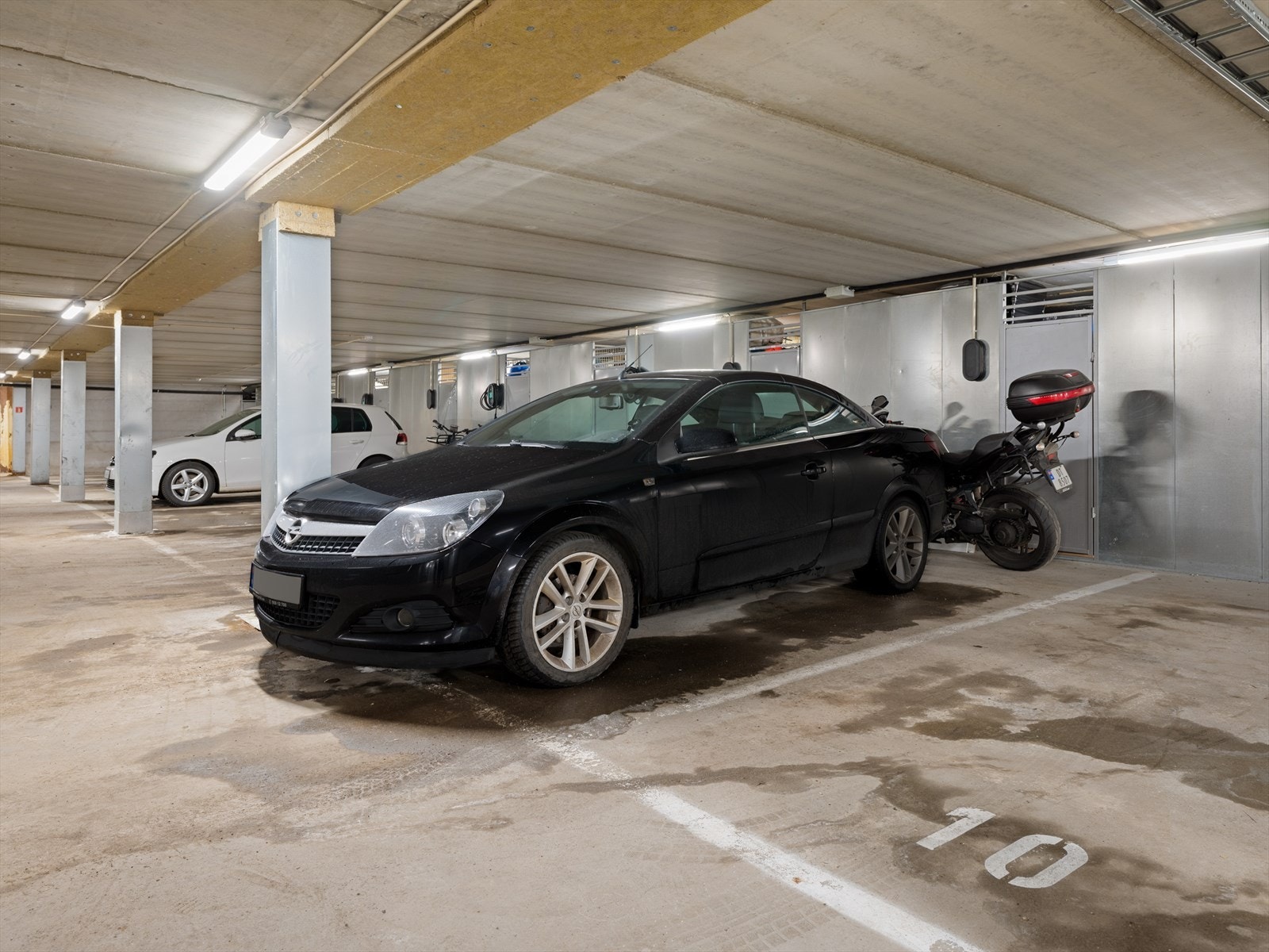 Med leiligheten følger en p-plass i gårdens garasjeanlegg. Det er også plass til å parkere en motorsykkel. Leilighetens bod ligger praktisk og lett tilgjengelig rett bak p-plassen. Det er allerede lagt klar infrastruktur til montering av ladeboks. Galleribilde