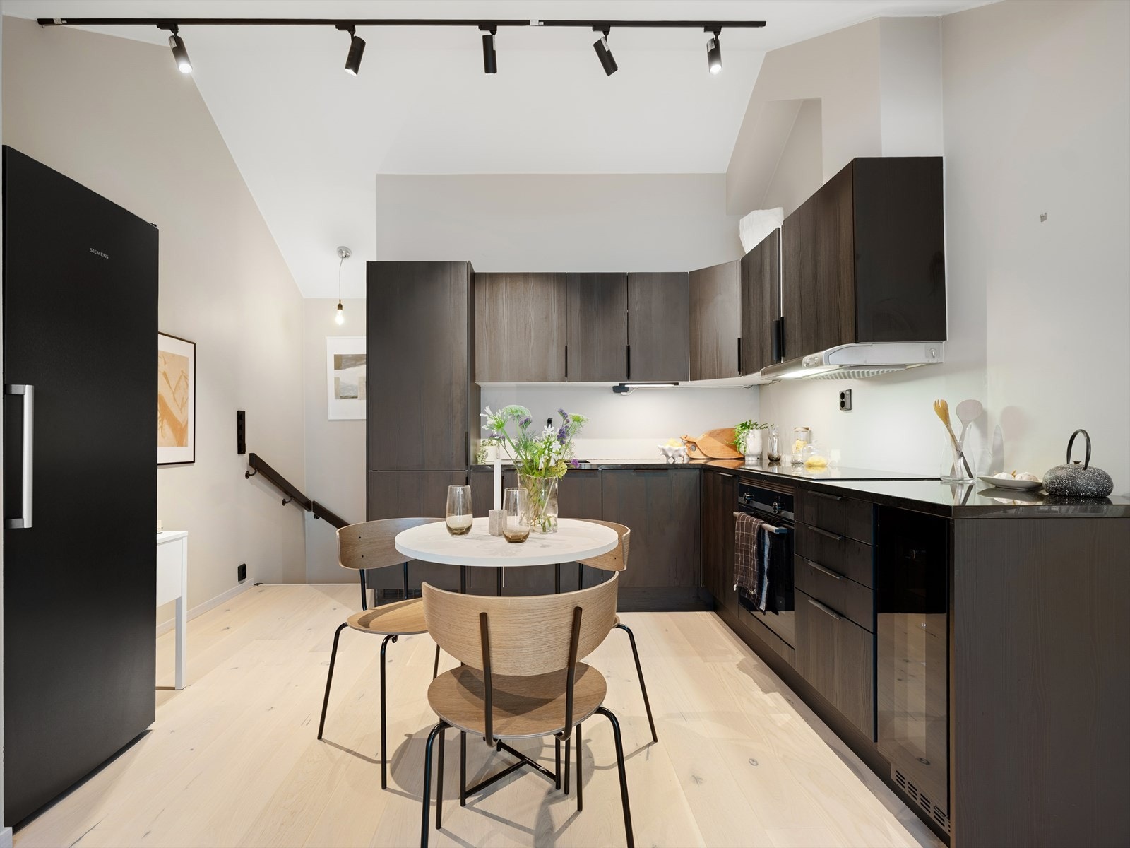 Kjøkkenet er stilrent og delikat med mørke, folierte fronter i trestruktur og mørk granitt benkeplate. Integrert komfyr med induksjons platetopp og oppvaskmaskin. Galleribilde