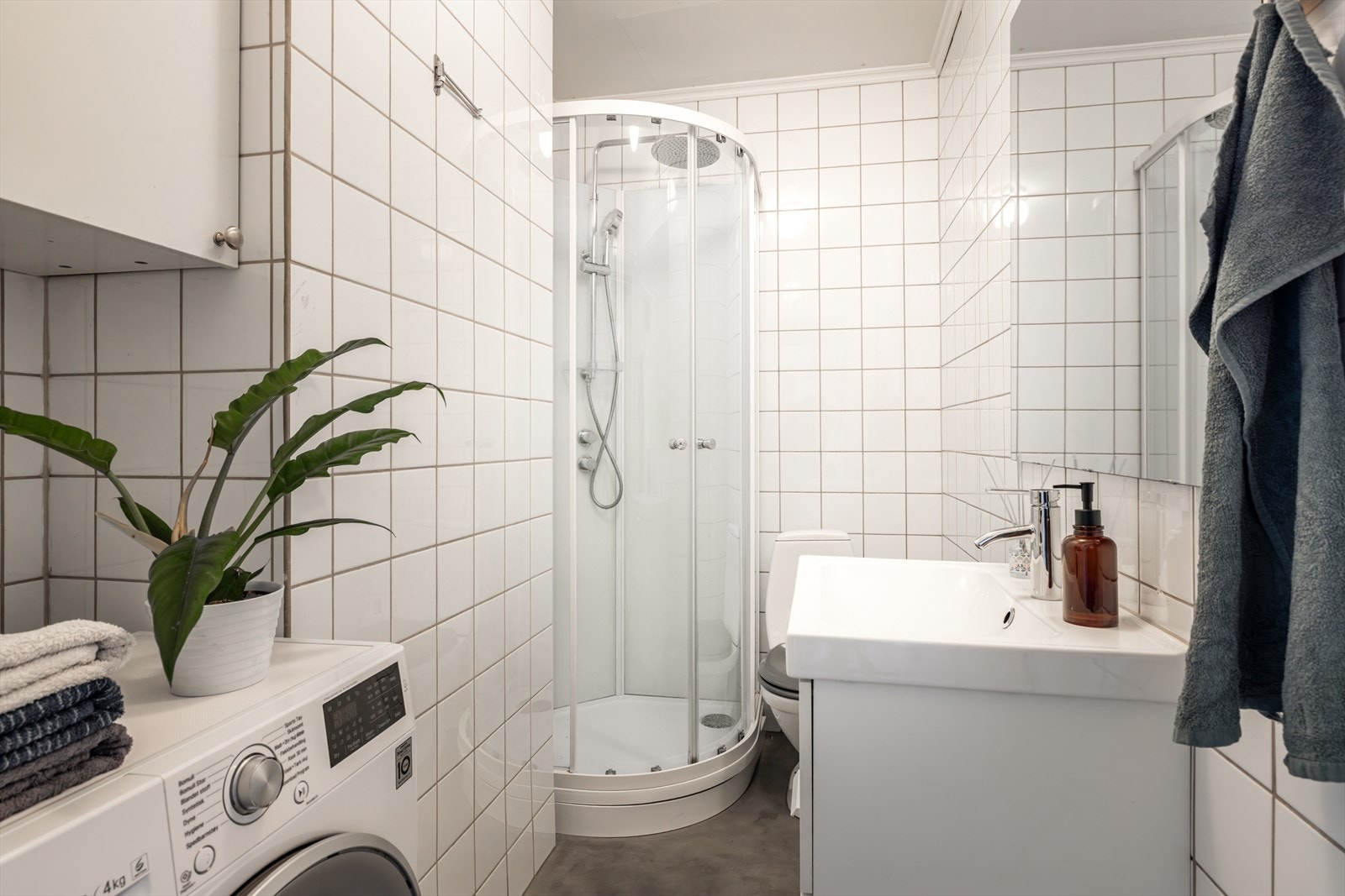 Baderomsinnredningen består av servantskap, dusjkabinett fra 2020, toalett og opplegg for vaskemaskin Galleribilde