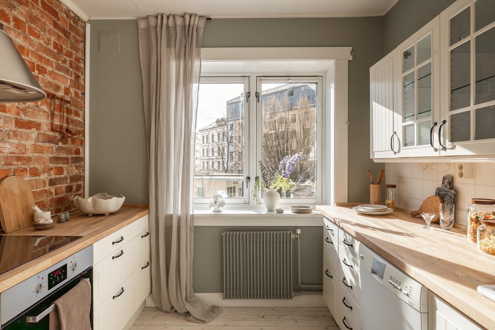 Separat IKEA-kjøkken fra 2013 innredet med hvite, profilerte fronter og benkeplate i tre Galleribilde