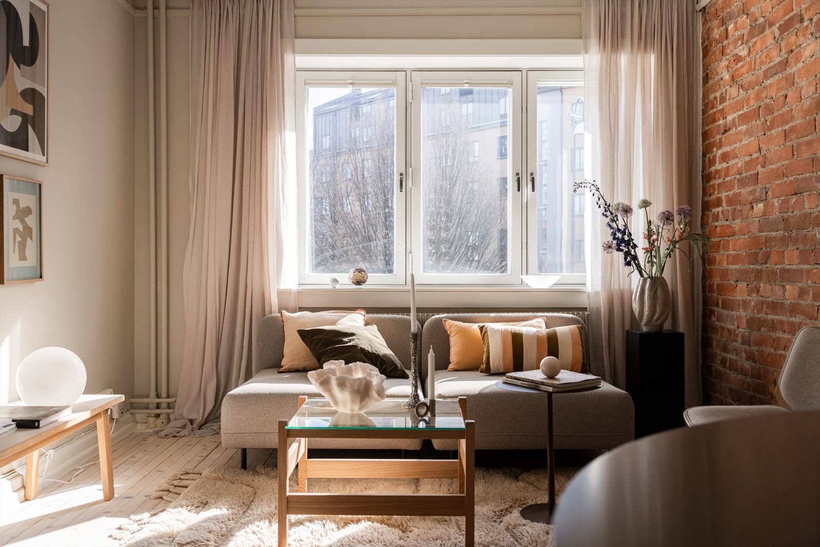 Lys stue med store vindusflater og nydelig teglsteinsvegg Galleribilde