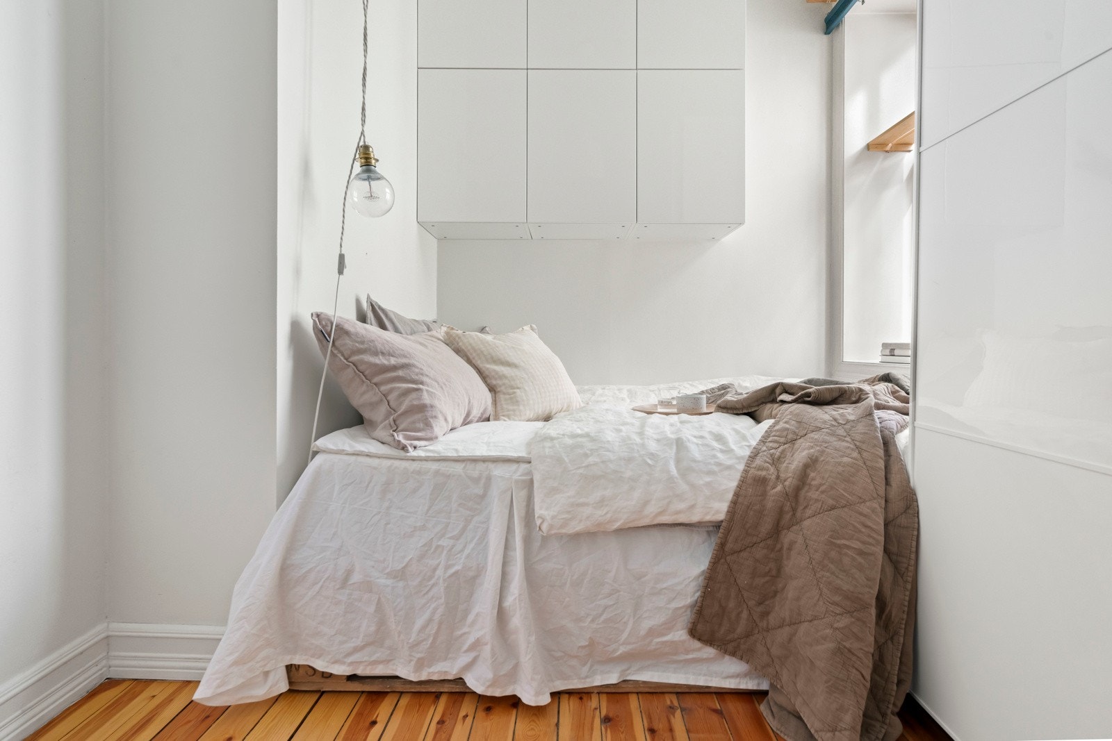 Ytterligere oppbevaringsplass i vegghengte skap over sengen. Galleribilde