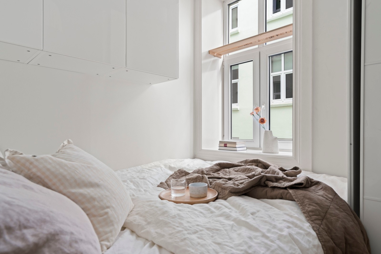 Langstrakt klassisk vindu med dype karmer vender ut mot rolig bakgård. Galleribilde