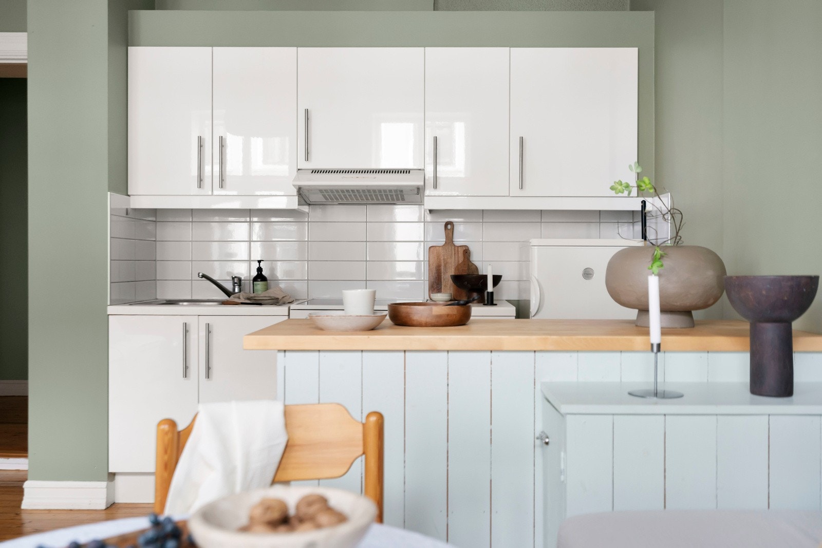 Pent tidløst kjøkken i lys utførelse med en praktisk kjøkkenøy. Galleribilde