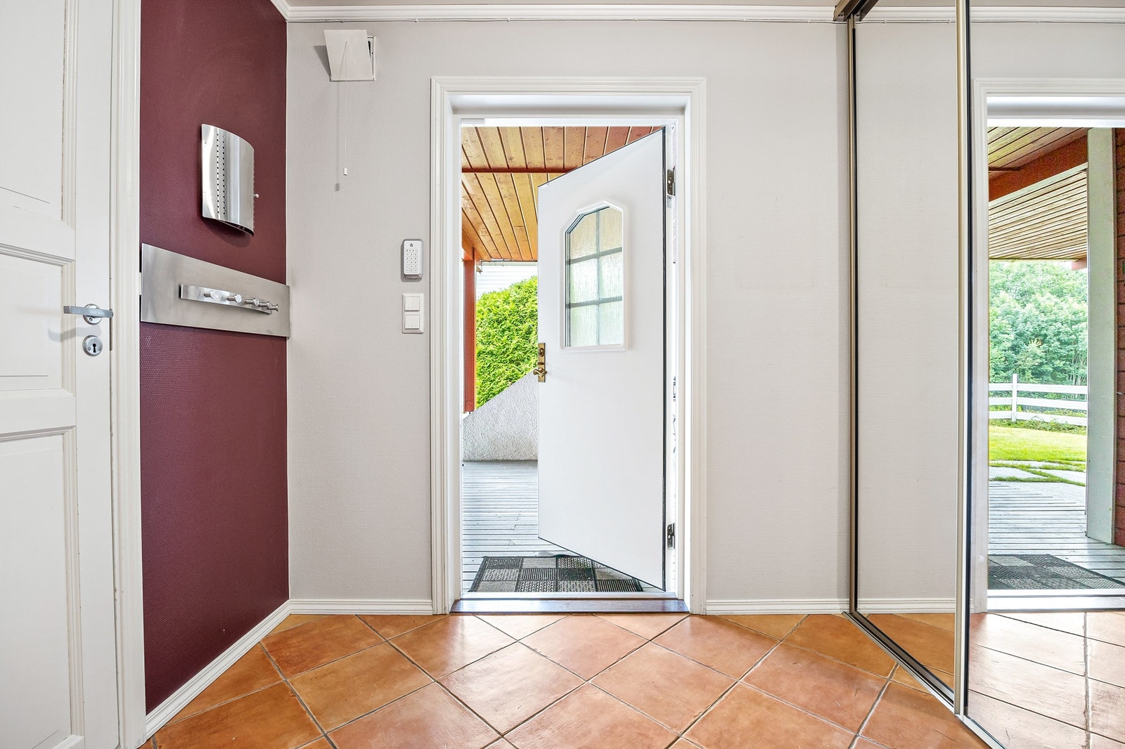 Gang med speilskyvedørsgarderobe ved inngangsdør og plassbygget skyvedørsgarderobe i enden av rommet Galleribilde