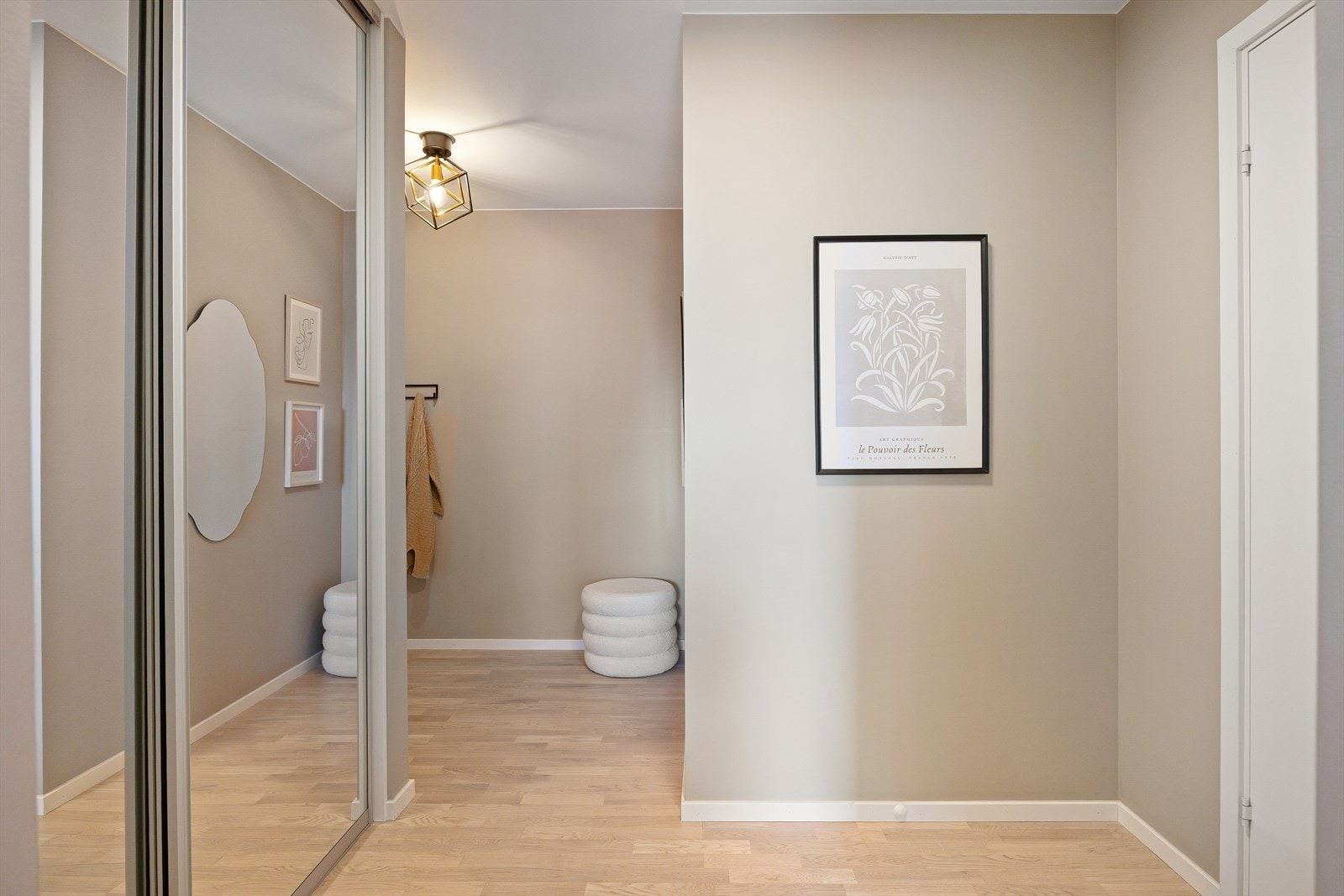 I gangen er det rikelig med plass til oppbevaring av yttertøy, både i den store skyvedørsgarderoben med speilfronter og på en praktisk knaggrekke. Galleribilde