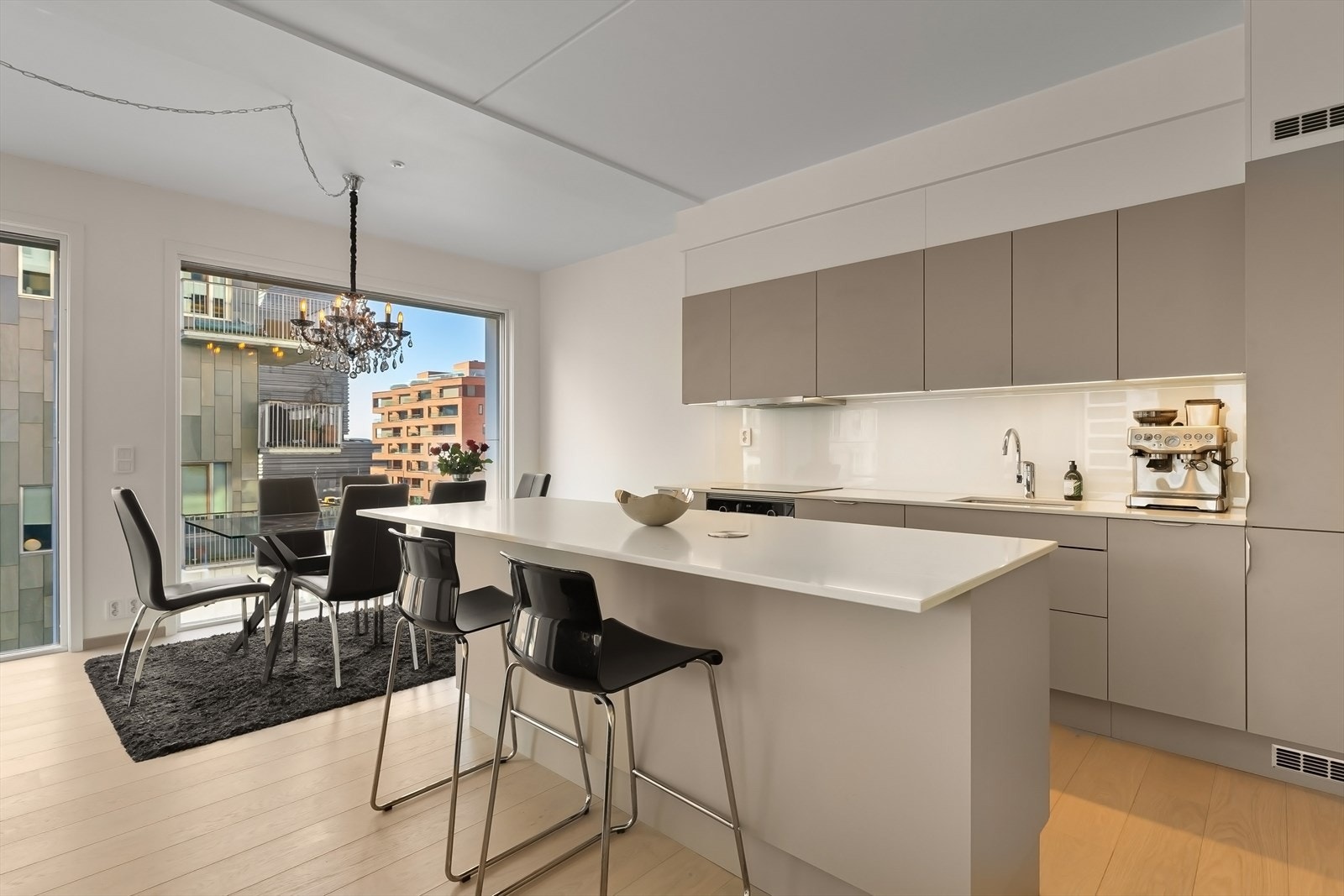 Lekkert HTH kjøkken med matte glatte fronter og kompositt benkeplate med underlimt vaskekum og nedfelt induksjon platetopp. Galleribilde