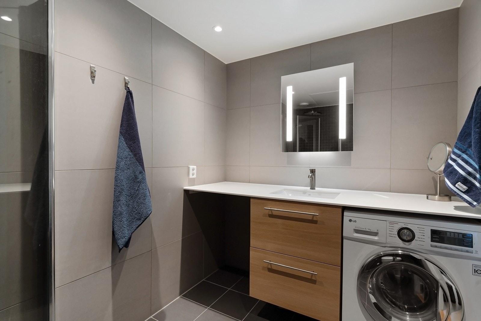 Badet består av flislagt gulv med varmekabler, flislagte vegger og senket og malt platehimling med LED belysning. Galleribilde