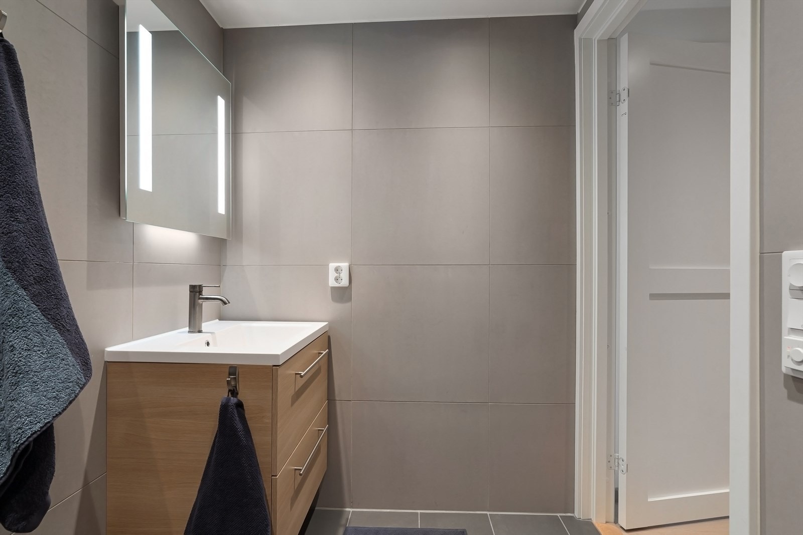 Badet består av flislagt gulv med varmekabler, flislagte vegger og senket og malt platehimling med LED belysning. Galleribilde