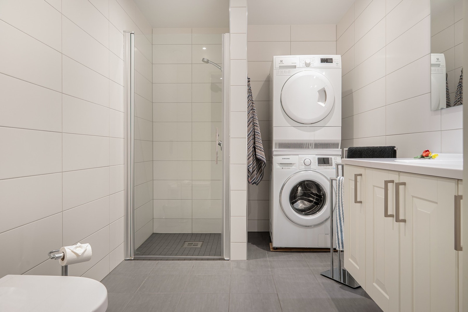 Badet er utstyrt med dusjnisje, vegghengt wc, servantinnredning og opplegg for vaskemaskin/tørketrommel. Galleribilde