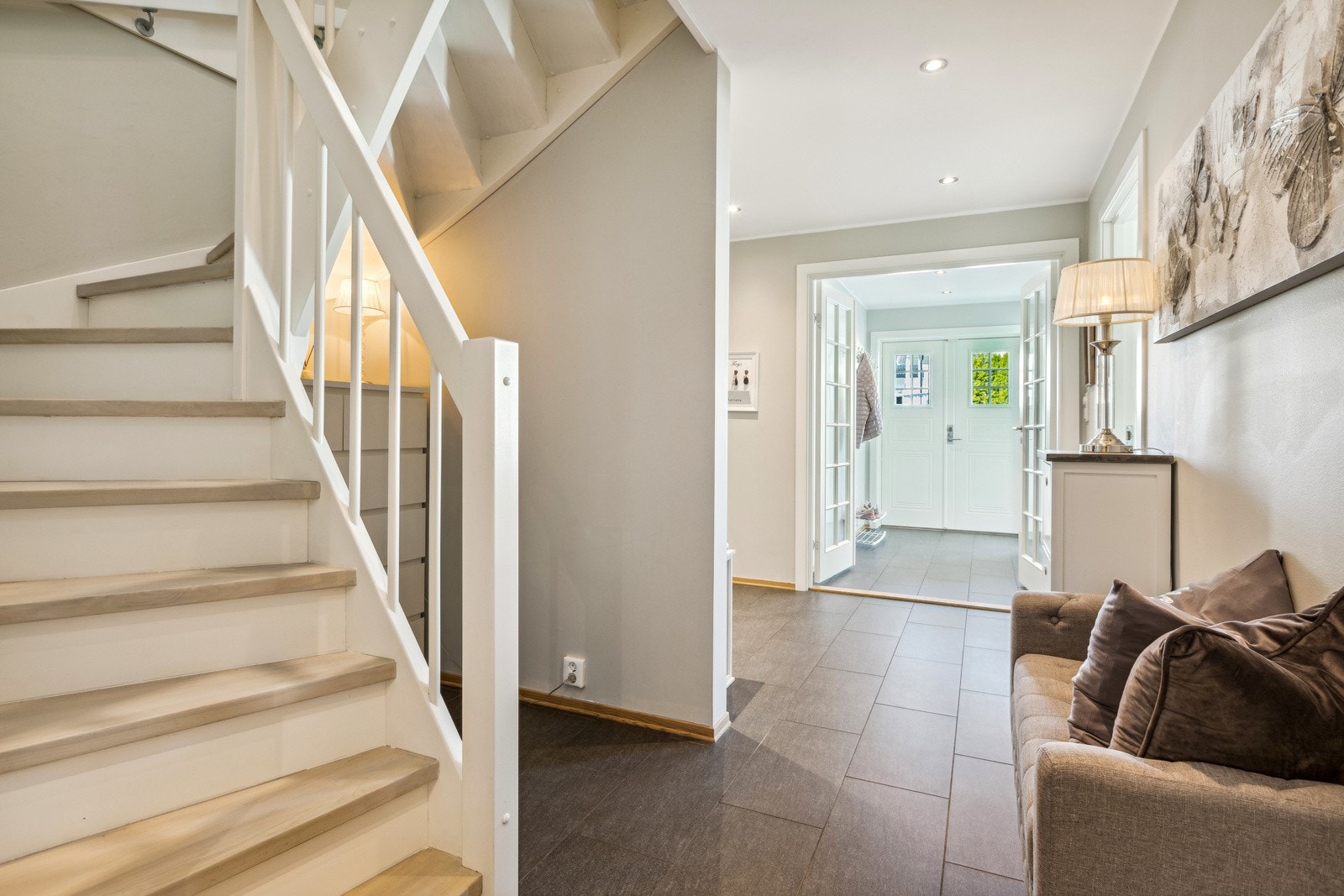 Innbydende entre med flislagt gulv og gulvvarme, samt malte flater på vegger som gir et godt førsteinntrykk av boligen. Galleribilde