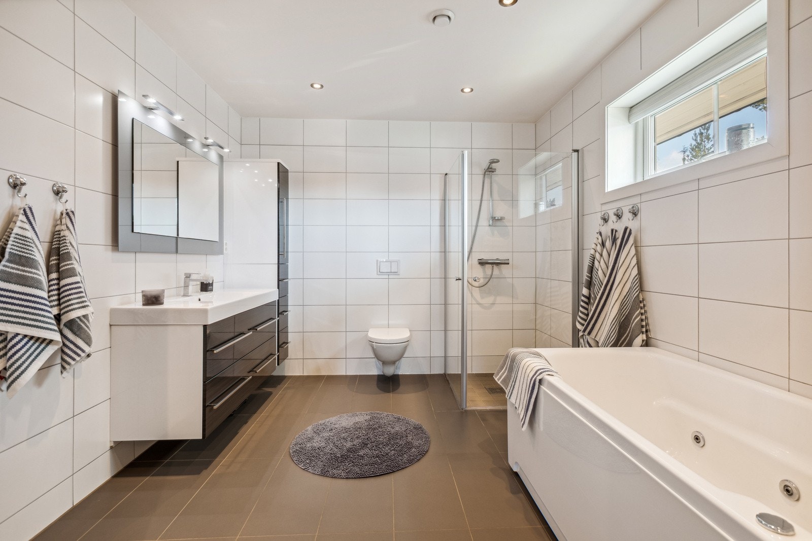 Delikat og smakfullt bad beliggende i tilknytning til hoved soverommet. Badet har flislagte overflater og elektrisk gulvvarme. Galleribilde