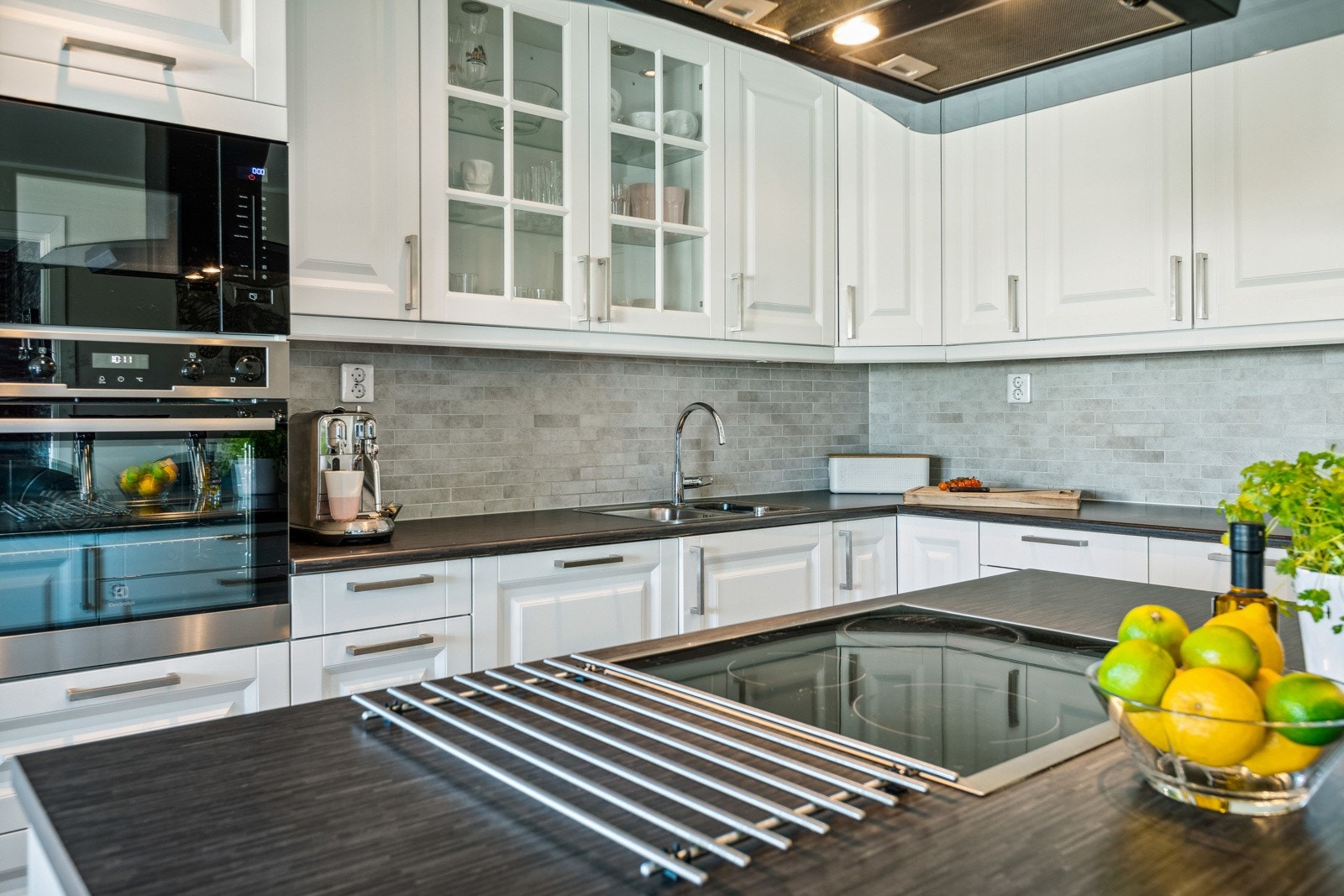 Innredningen består av profilerte fronter med takhøye overskap, samt enkelte glassfronter i overskap. Laminat benkeplate med nedfelt oppvaskkum i rustfritt stål. Galleribilde