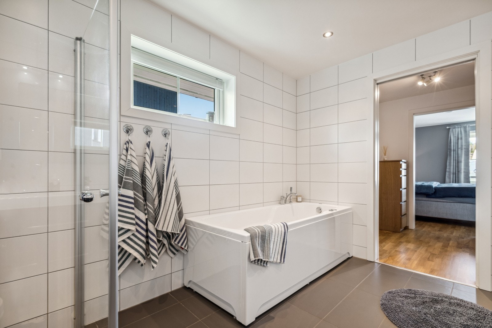 Innredningen består av vegghengt servantskap med heldekkende servant og tilhørende høyskap. Badet har i tillegg dusjnisje med innfellbare glassdører og badekar. Innebygget sisterne med vegghengt klosett. Galleribilde