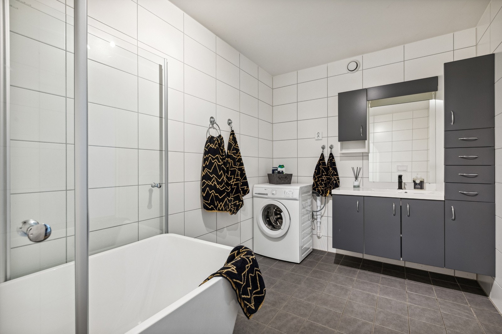 Utleie: Flislagt bad med elektrisk gulvvarme. Baderomsinnredning bestående av benkeskap med glatte fronter og tilhørende. veggskap. Galleribilde