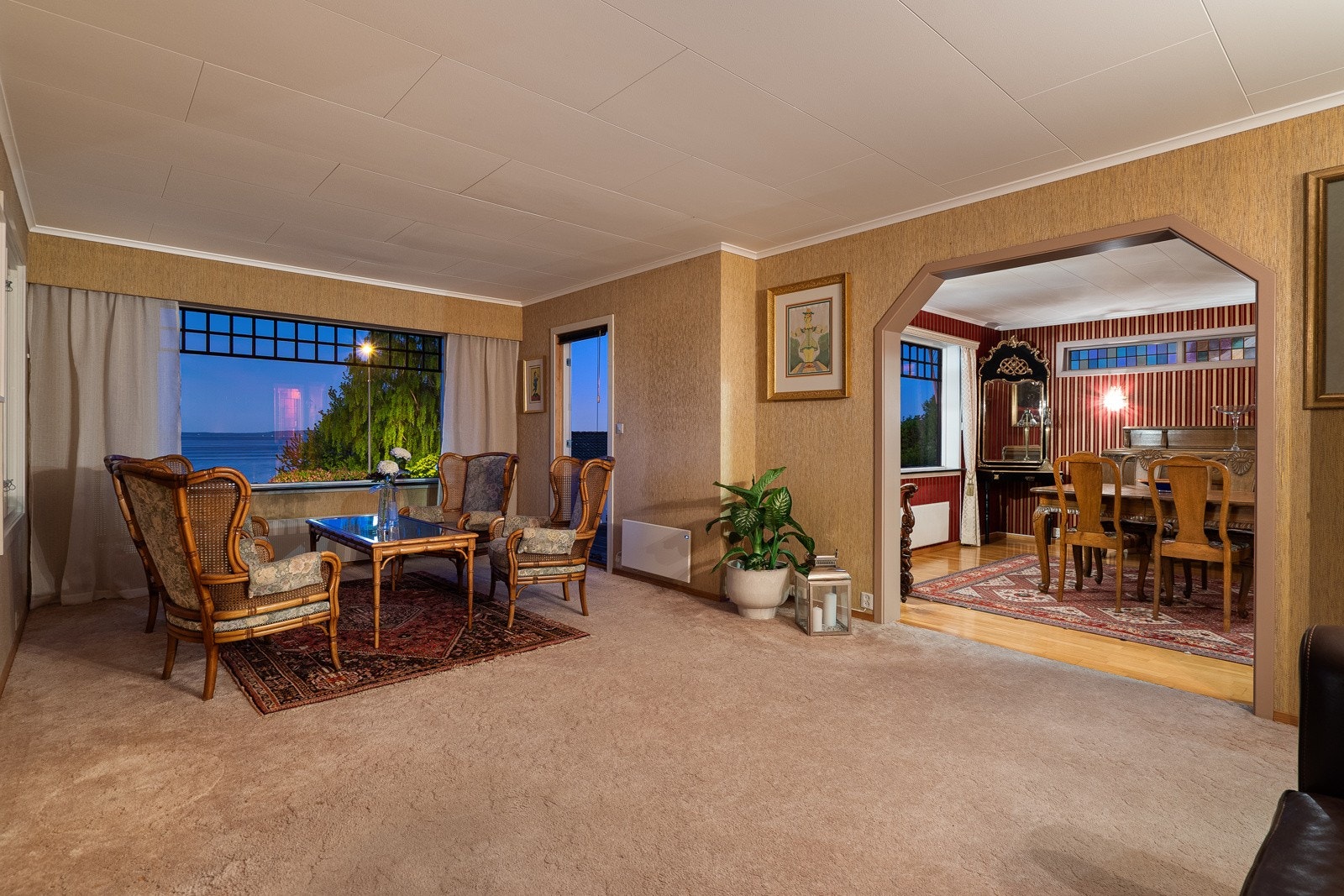 Hovedstua med god plass til ulike møblement og utgang til terrasse mot sjøen Galleribilde