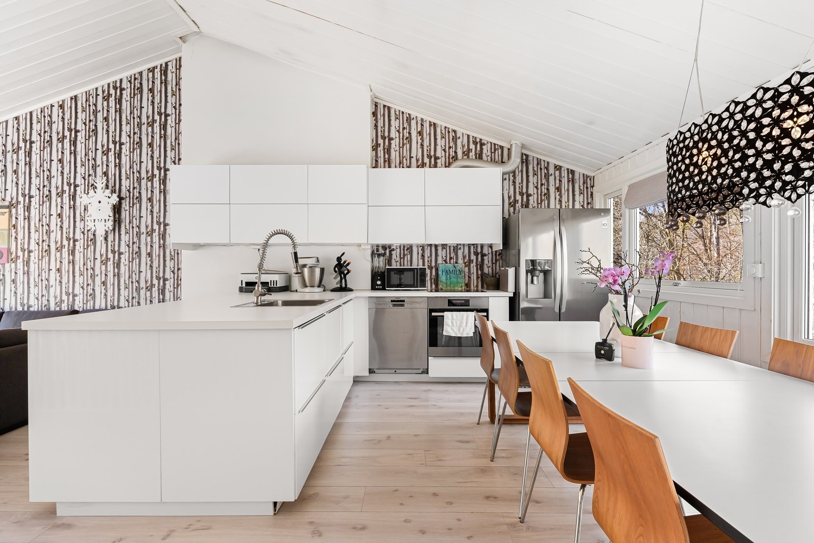 Kjøkkenet har slette fronter på skap og skuffer, benkeplate av laminat med nedfelt oppvaskkum og integrerte hvitevarer med platetopp, stekeovn og oppvaskmaskin, samt plass for frittstående kjøleskap Galleribilde