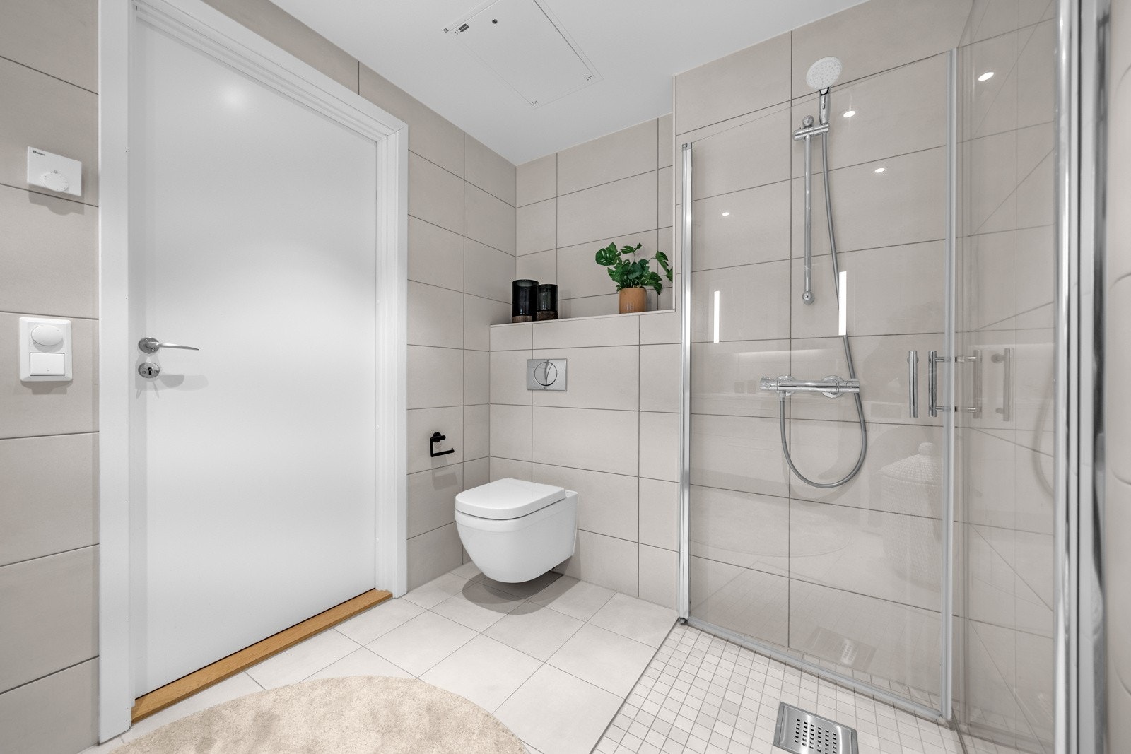 Delikat baderom med gulvvarme og opplegg for vaskemaskin og tørketrommel Galleribilde